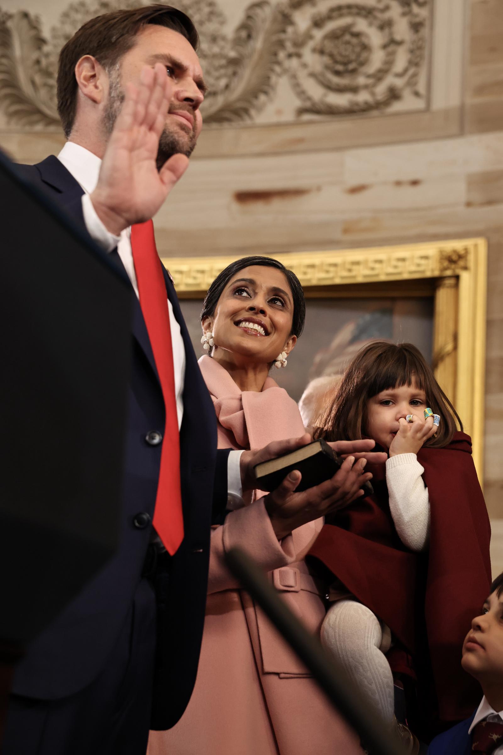 JD Vance being sworn in as Usha Vance holds a bible and their daughter. | Source: Getty Images