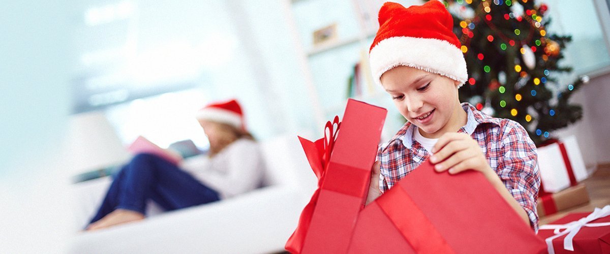 A young boy unwrapping his Christmas gift | Photo: Getty Images