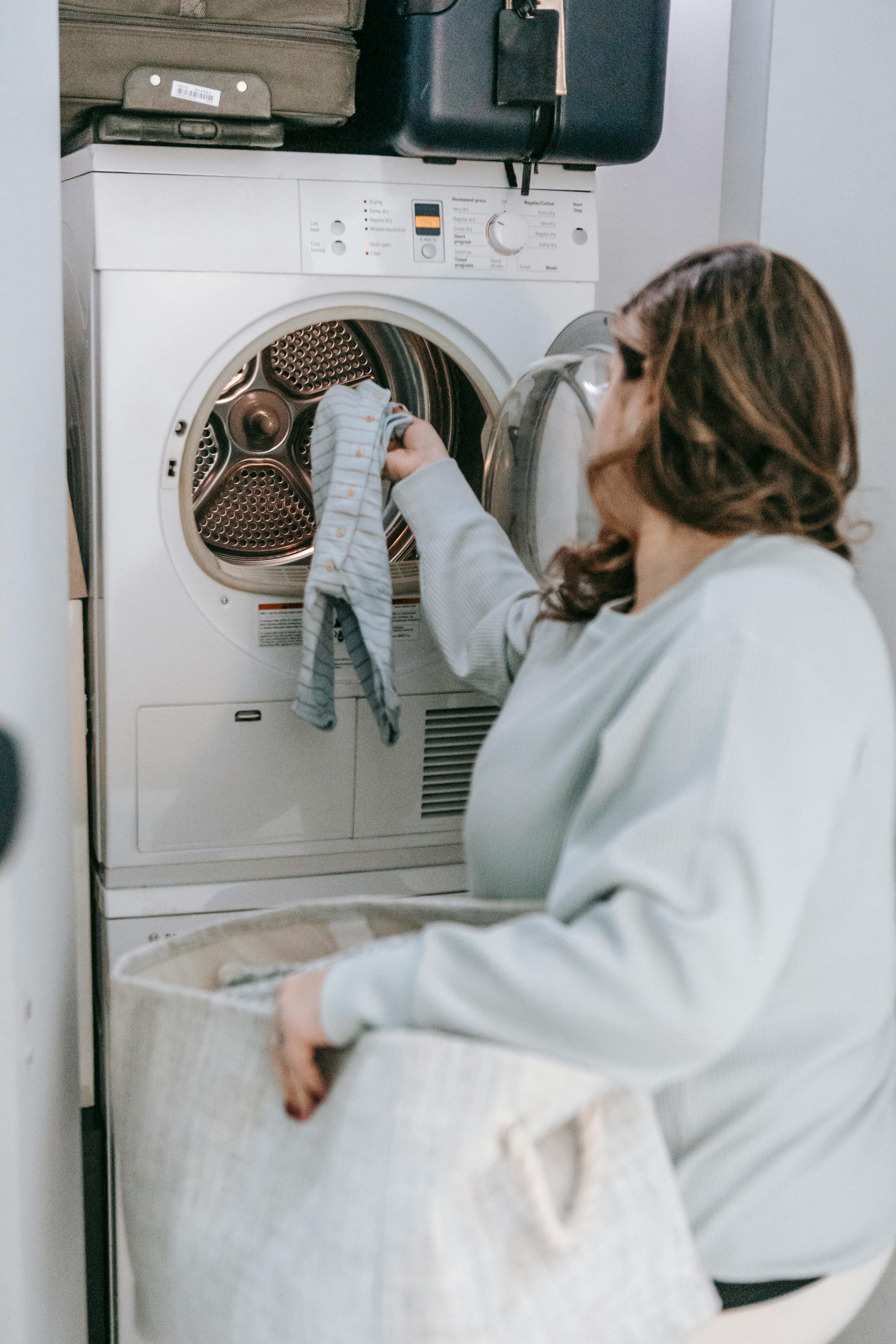 A woman loading her washing machine | Source: Pexels