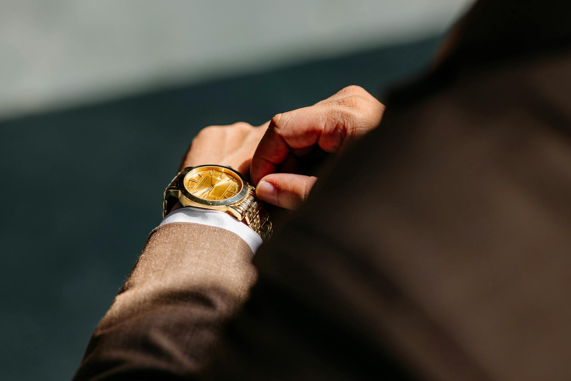 A close-up shot of a man in a suit touching his wristwatch | Source: Pexels