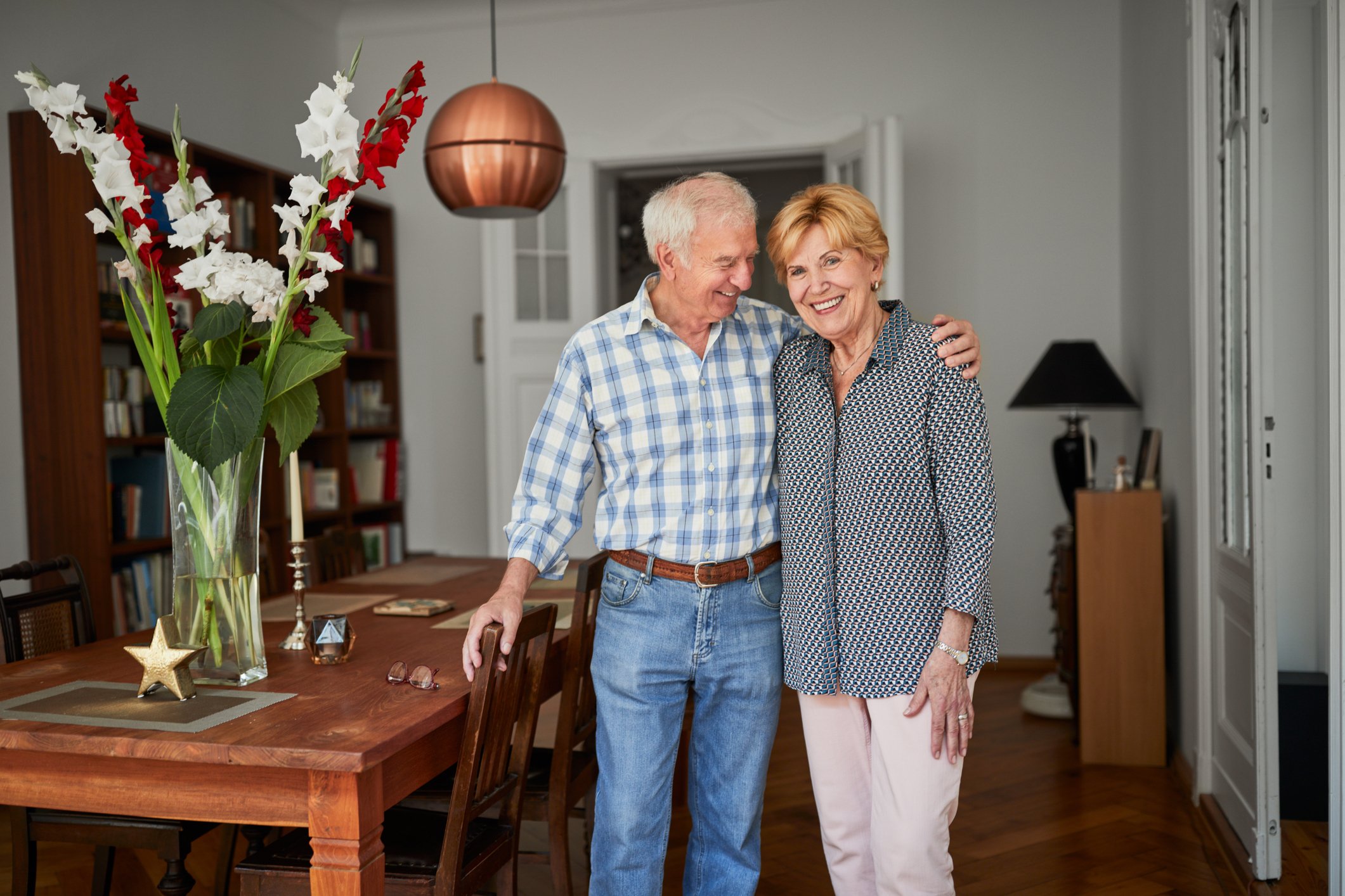 A portrait of a happy couple at home smiling and standing together. | Photo: Getty Images