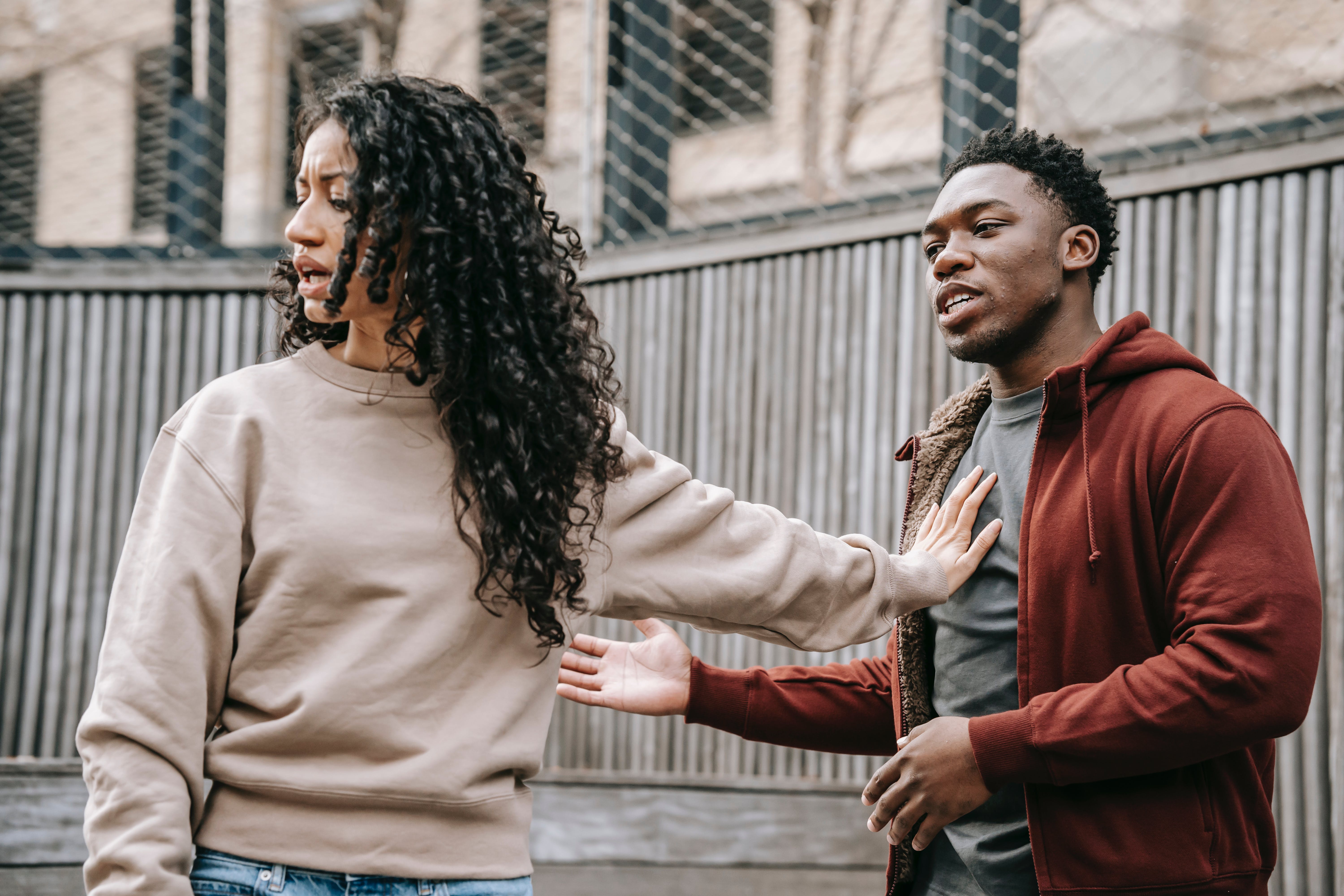 A man and woman in the middle of a disagreement with the latter pushing the former away | Source: Pexels
