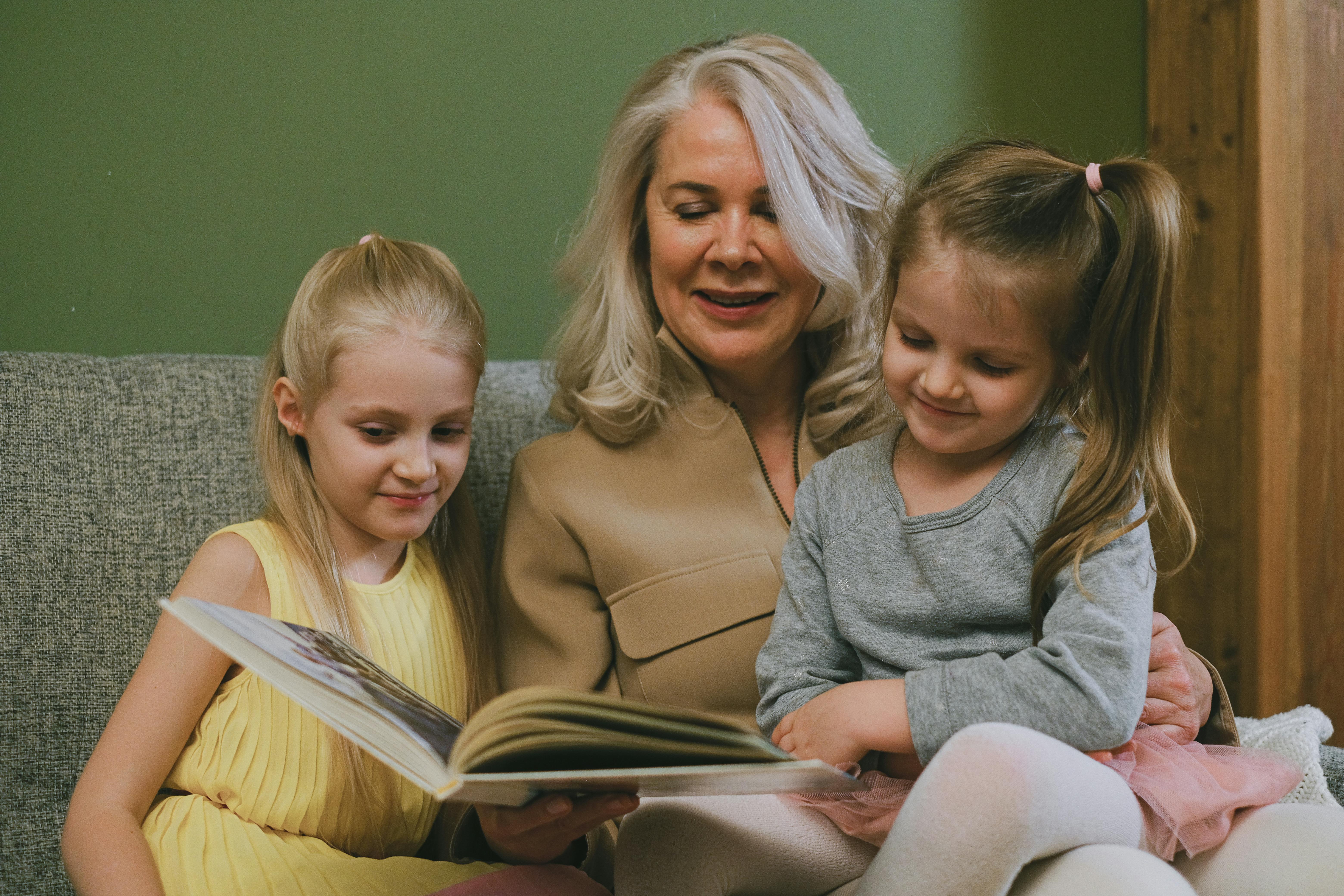 A woman reading a story to her grandchildren | Source: Pexels