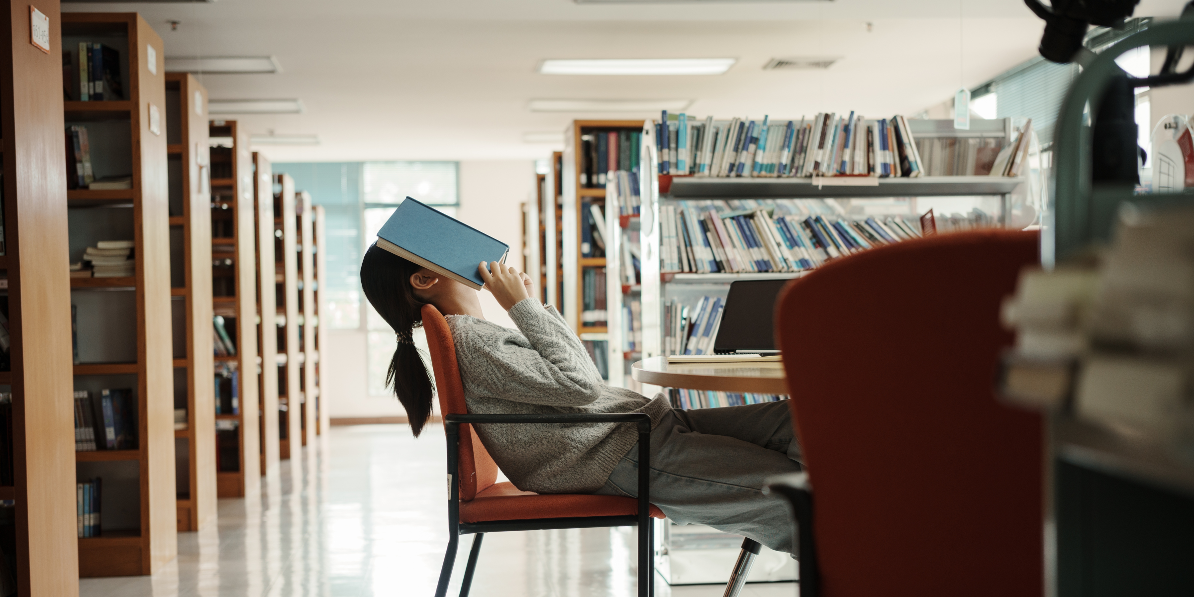 Stressed girl in the library | Source: Shutterstock