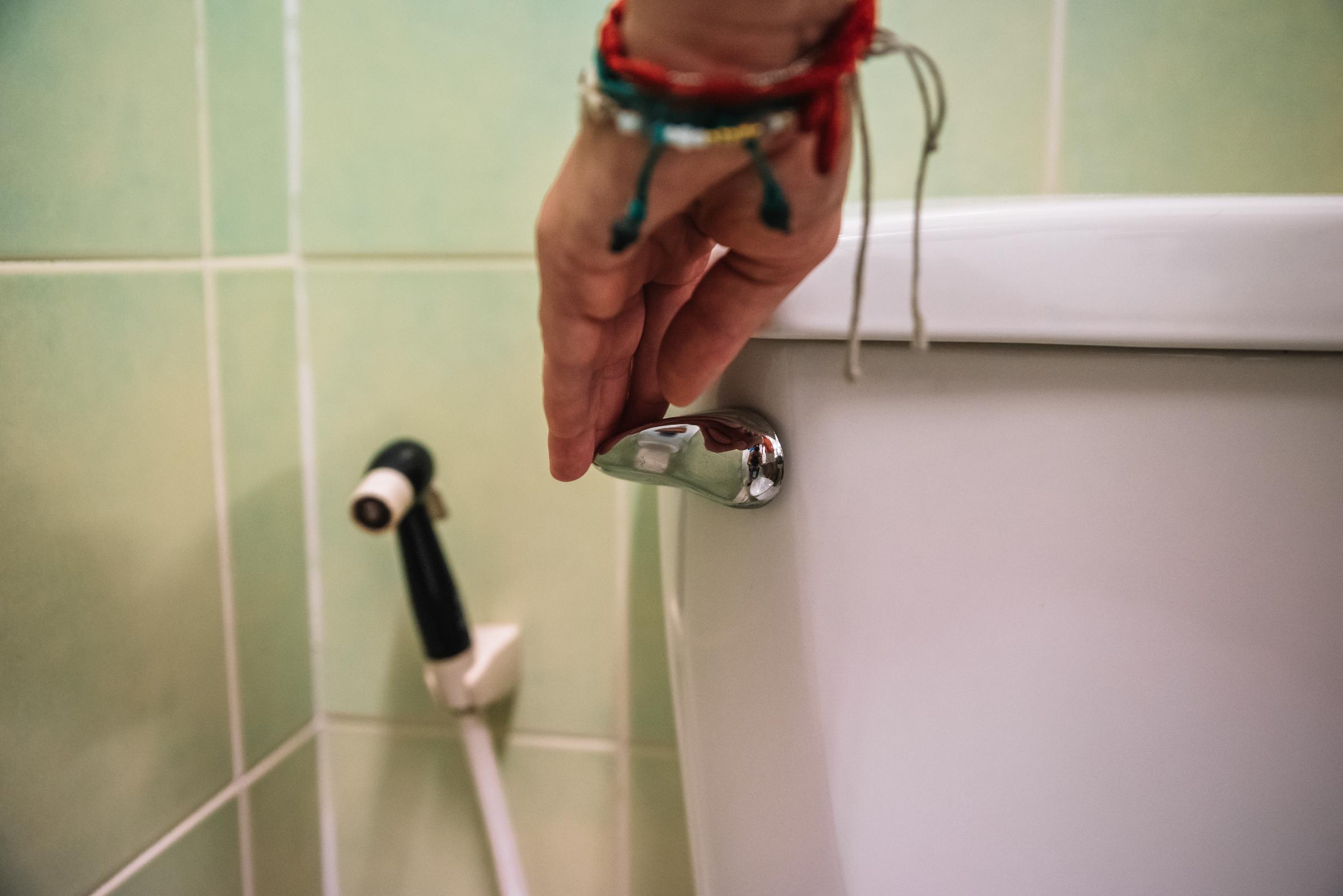 Close-up of a hand flushing a toilet | Source: Getty Images