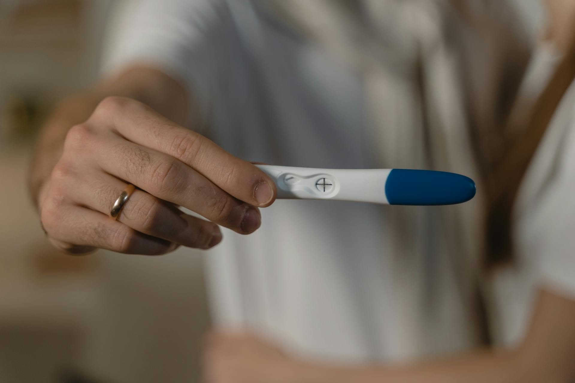 A man holding out a pregnancy test | Source: Pexels