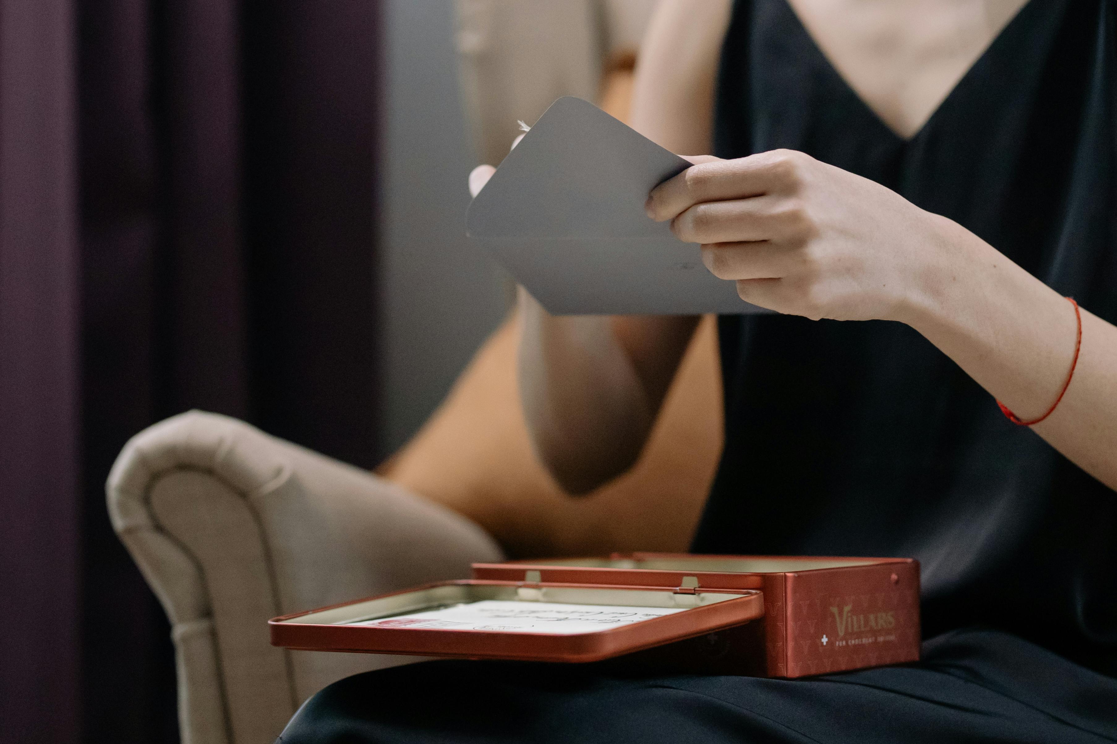 Woman opening a grey envelope | Source: Pexels