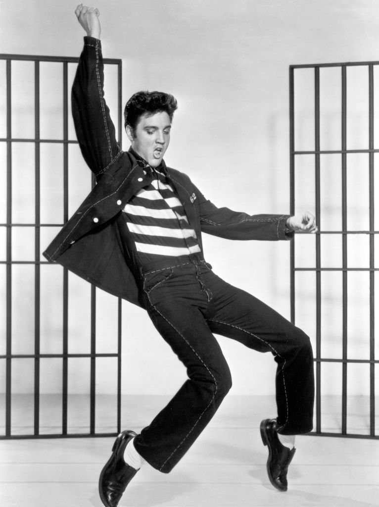 Elvis Presley dancing in a stylized prison uniform in a promotional portrait for director Richard Thorpe's film, "Jailhouse Rock" | Photo: Getty Images