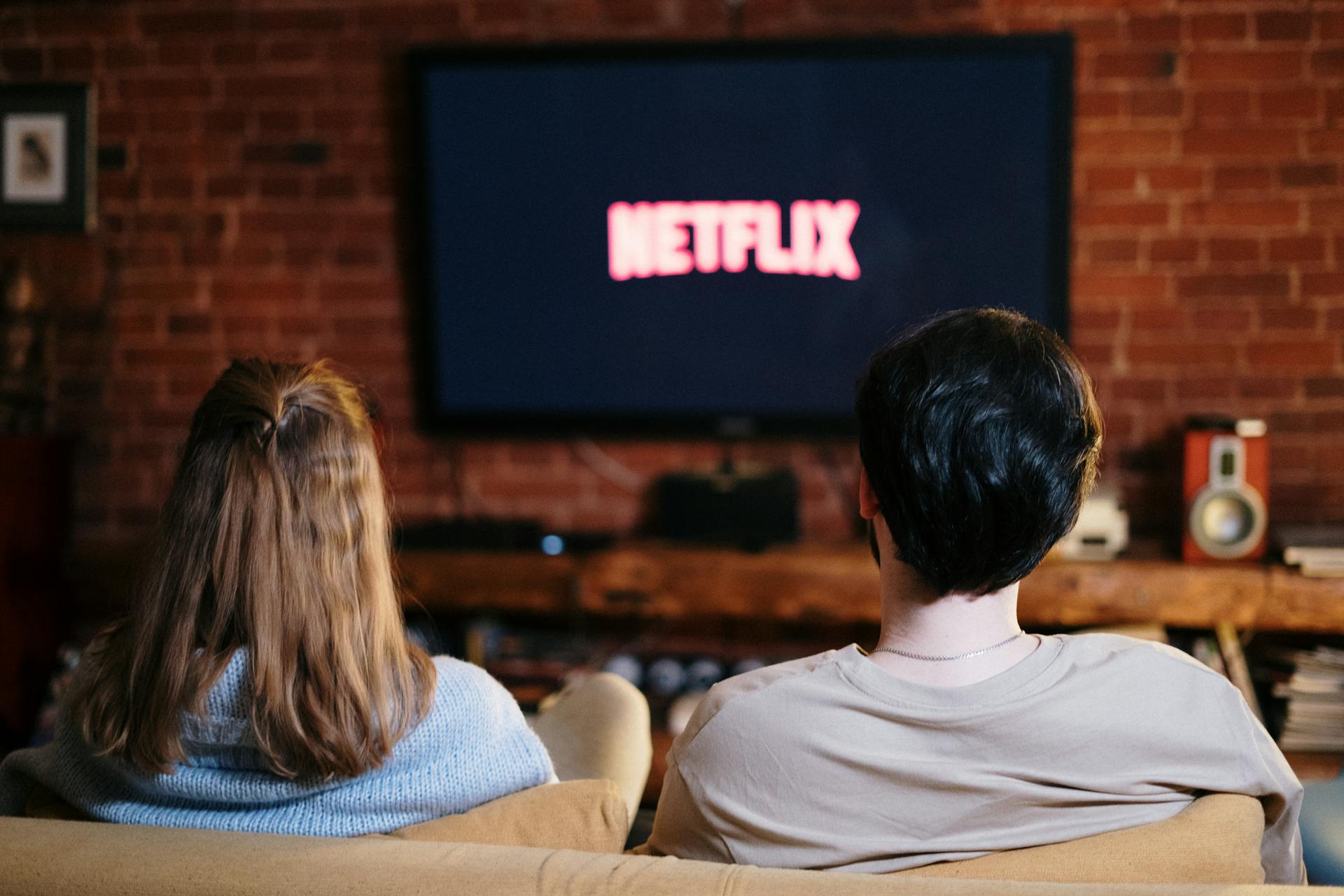 A couple sitting on a couch watching Netflix | Source: Pexels