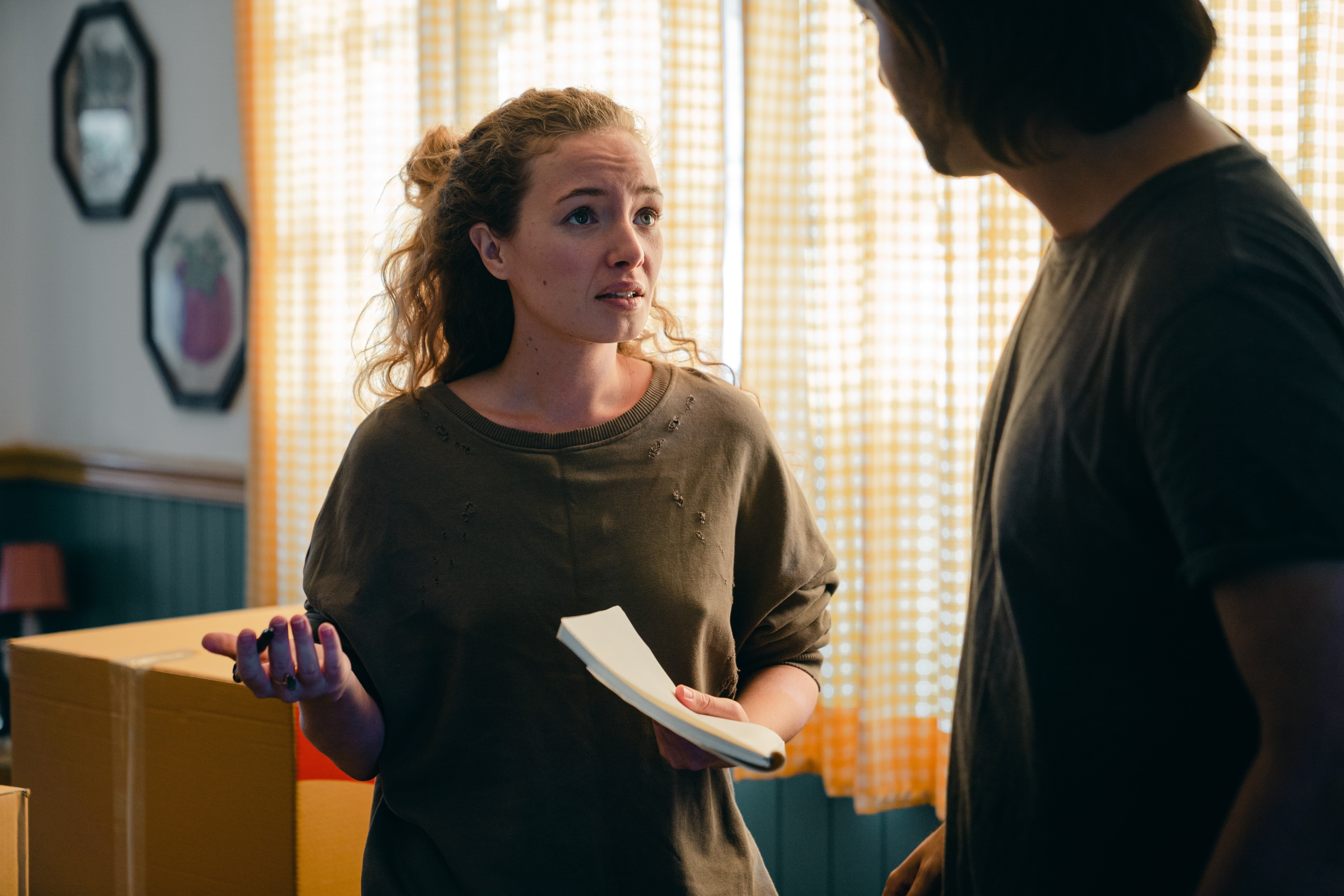 A woman talking to a man while holding a notepad and a pen | Source: Pexels