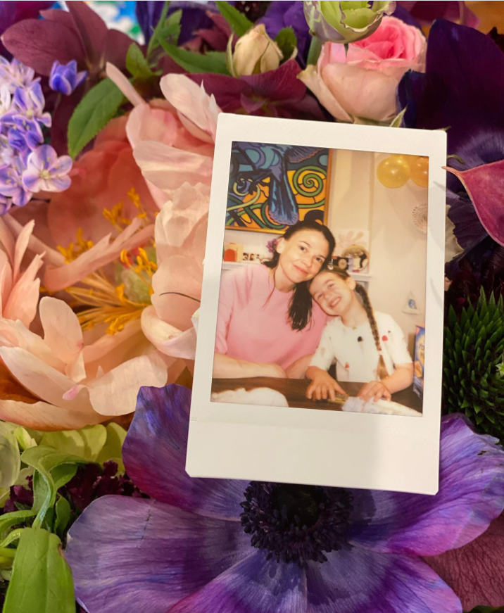 Sutton Foster and her daughter, Emily, smile together in a framed instant photo surrounded by colorful flowers. | Source: Instagram/suttonlenore