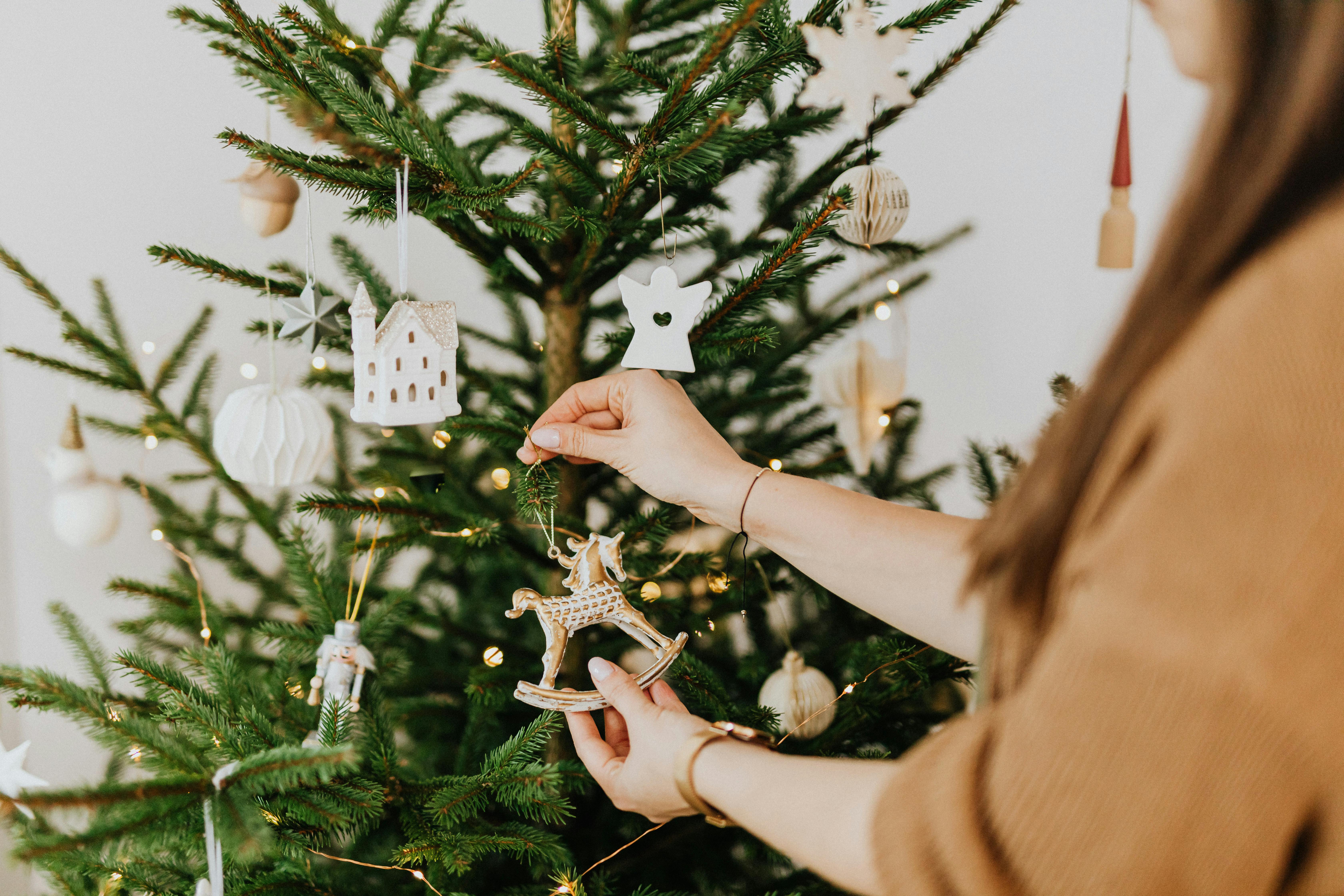 A woman decorating a Christmas tree | Source: Pexels