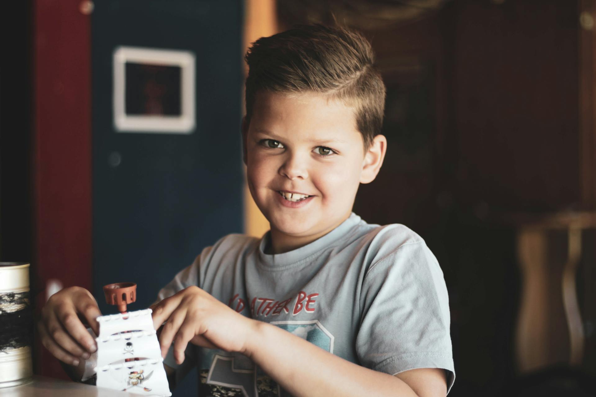 A smiling boy holding a toy | Source: Pexels