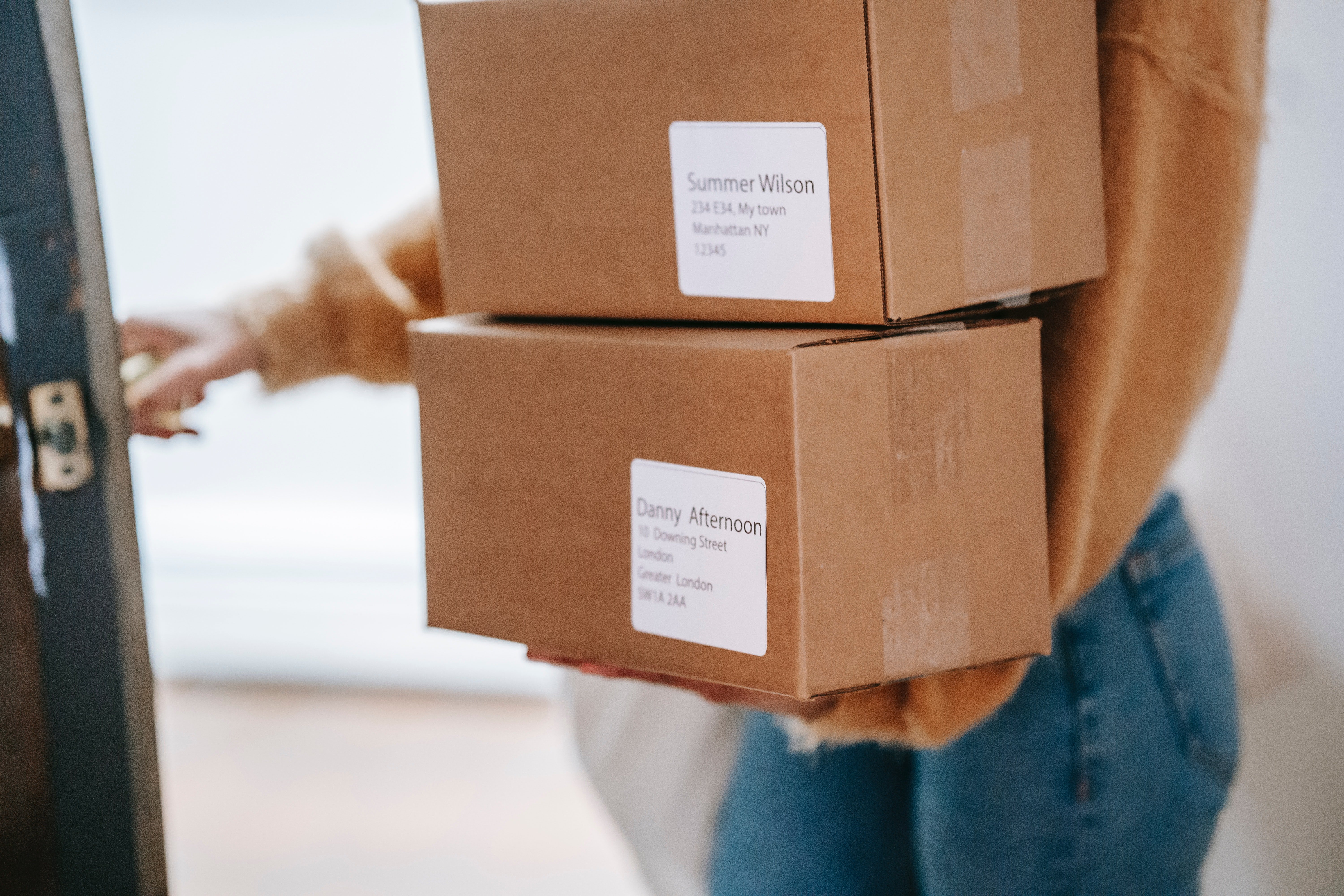 Una mujer carga varias cajas. | Foto: Pexels