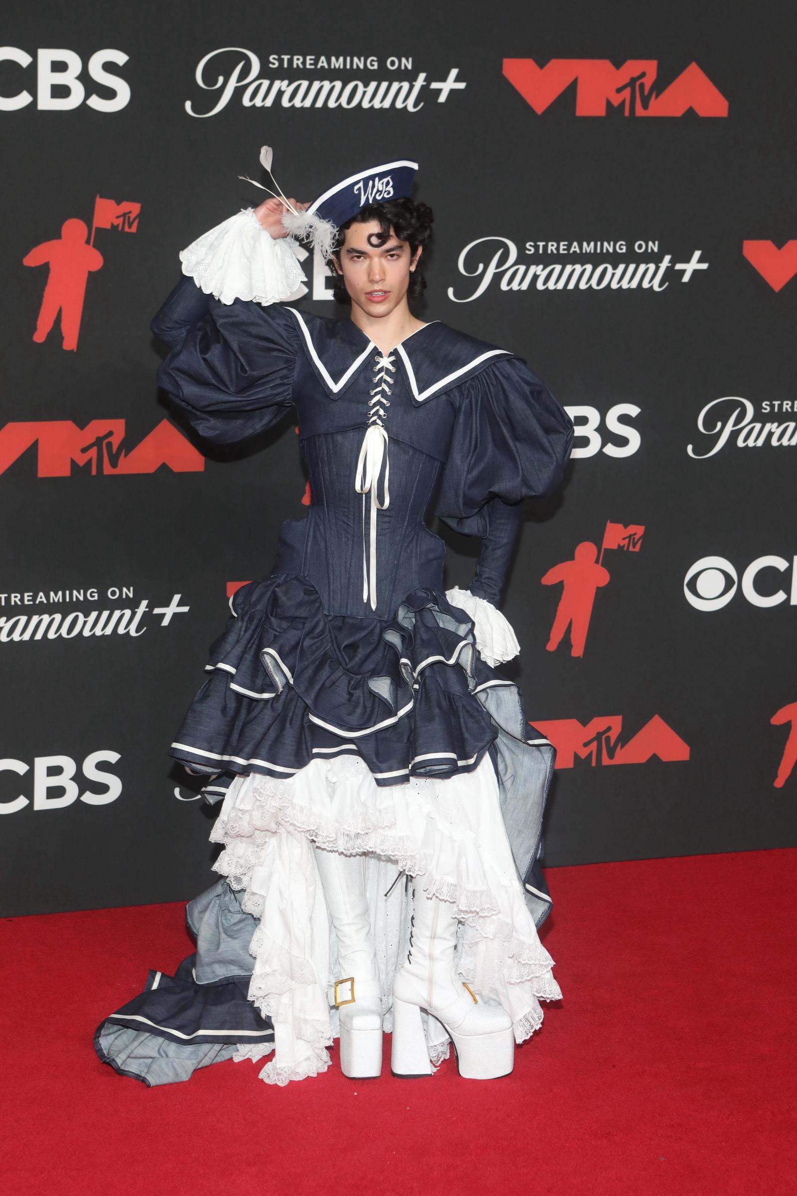 Conan Gray makes a statement at the 2025 MTV VMAs in a dramatic navy sailor-inspired gown with puffed sleeves, lace layers, and platform boots.