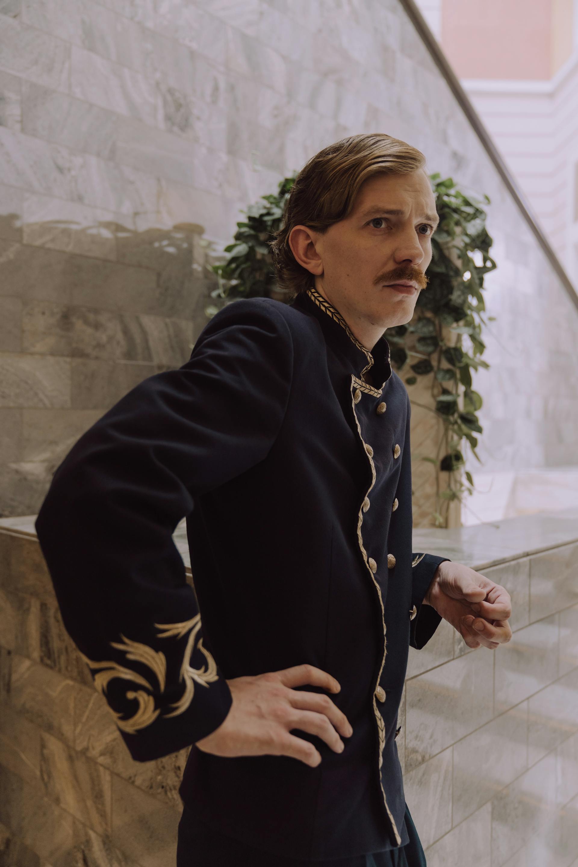 A man in a hotel concierge uniform with a serious expression | Source: Pexels