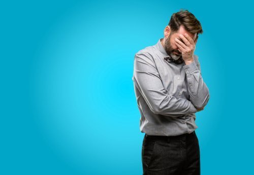 Frustrated man with his head in his hand. | Source: Shutterstock.