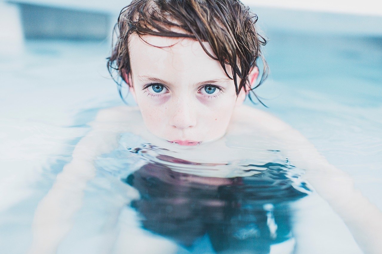 Un petit garçon nageant. | Photo : Pixabay