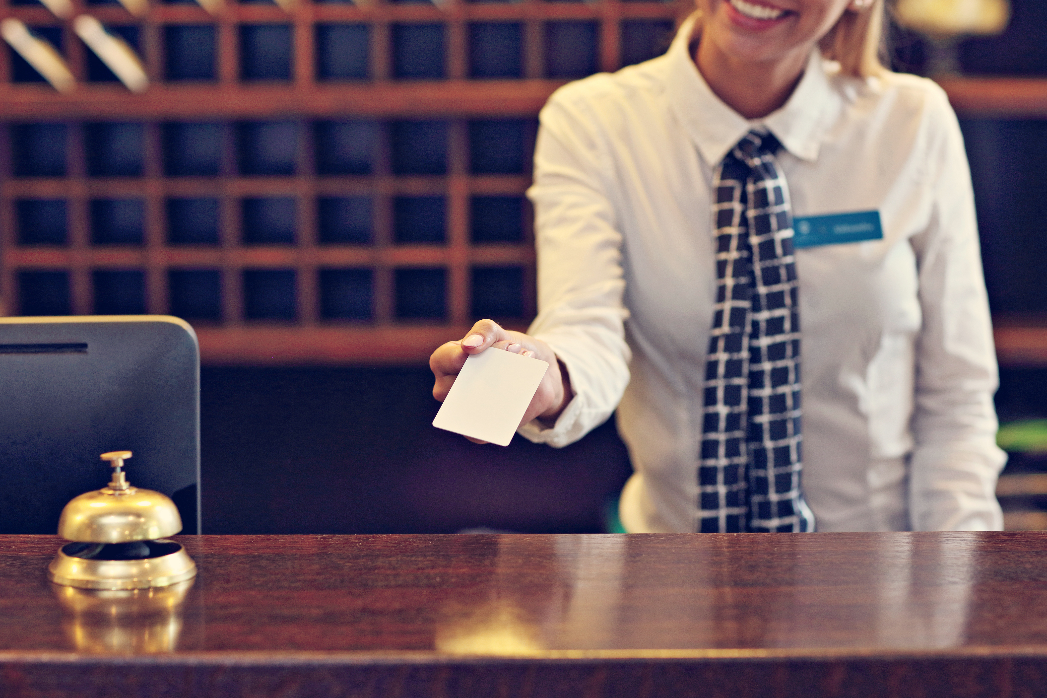 Picture of receptionist giving key card. | Source: Shutterstock