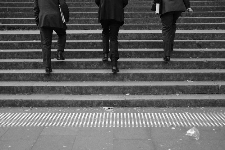 Drei Männer bewegen sich die Treppe hinauf. | Quelle: Getty Images