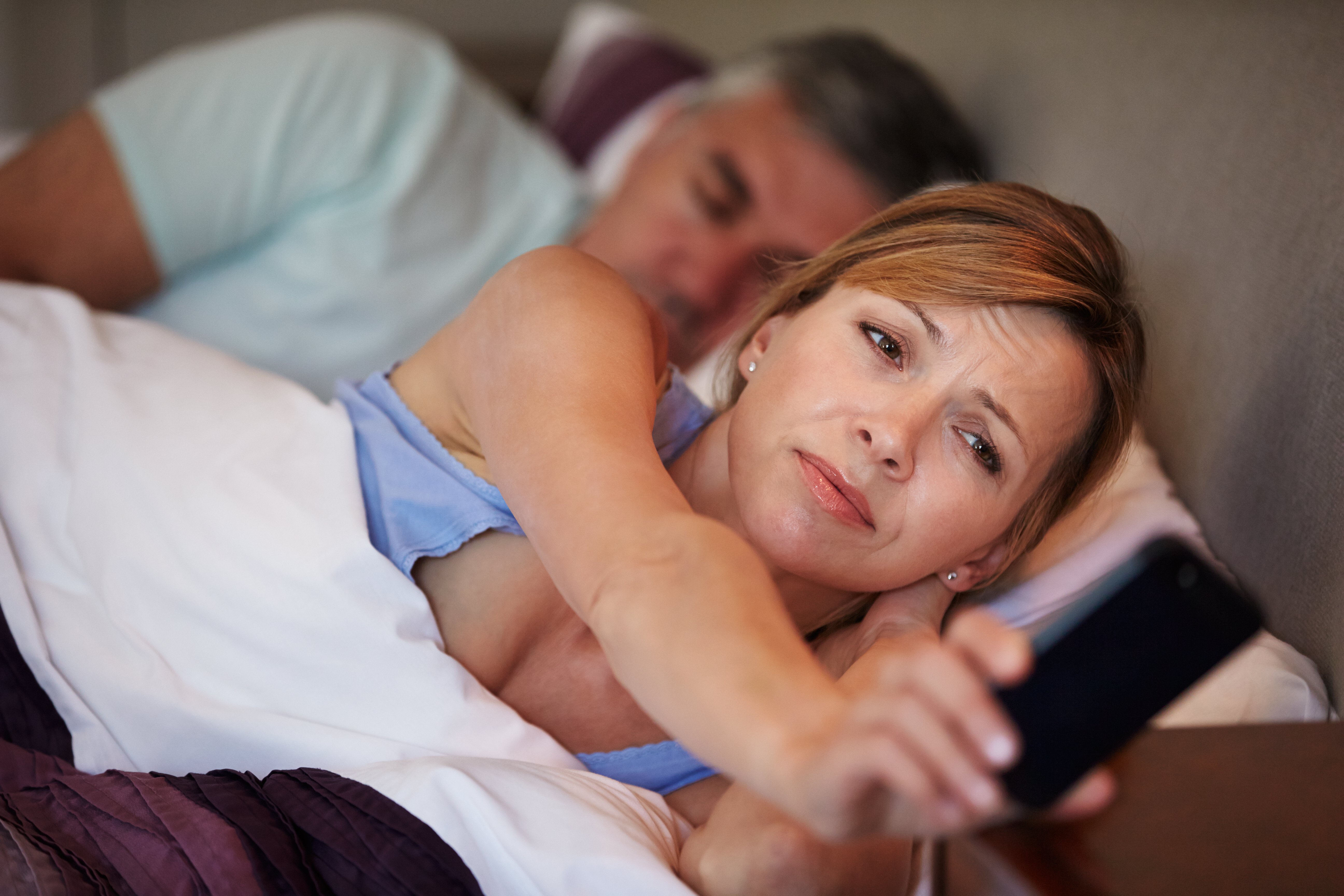 Mujer despierta mientras su marido duerme . | Foto: Shutterstock