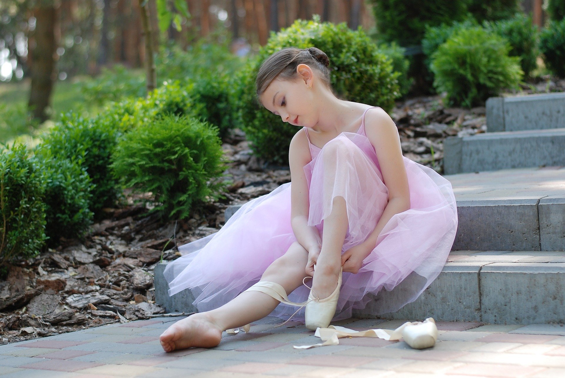 A young girl putting on her ballet shoes. | Source: Pixabay.
