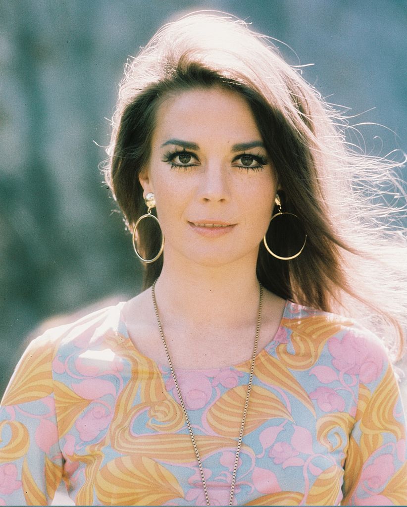 US actress, wearing a print pattern top with a large gold necklace and gold hoop earrings, circa 1975.  | Source: Getty Images