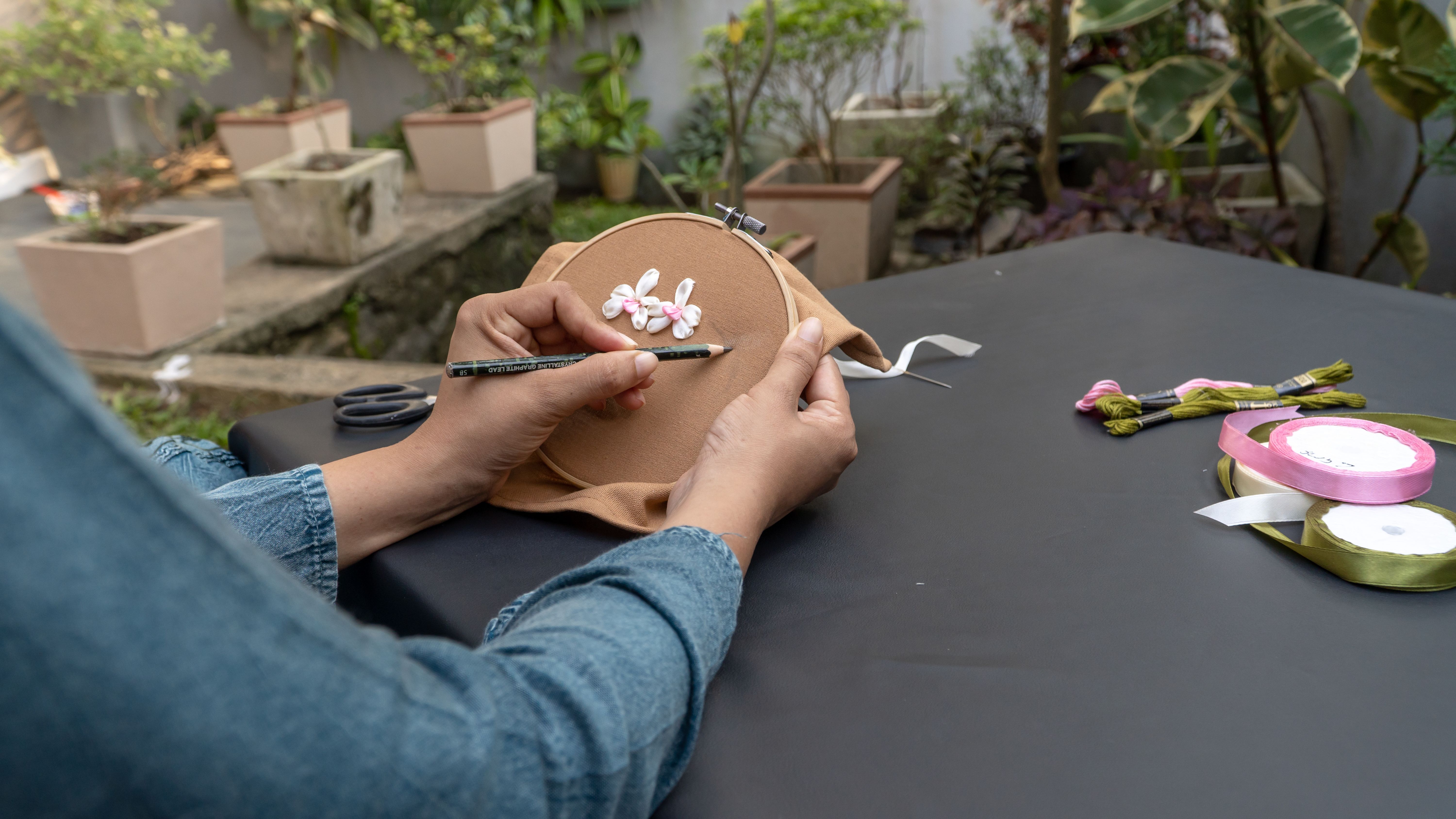 Woman working on hand-embroidered art | Source: Pexels