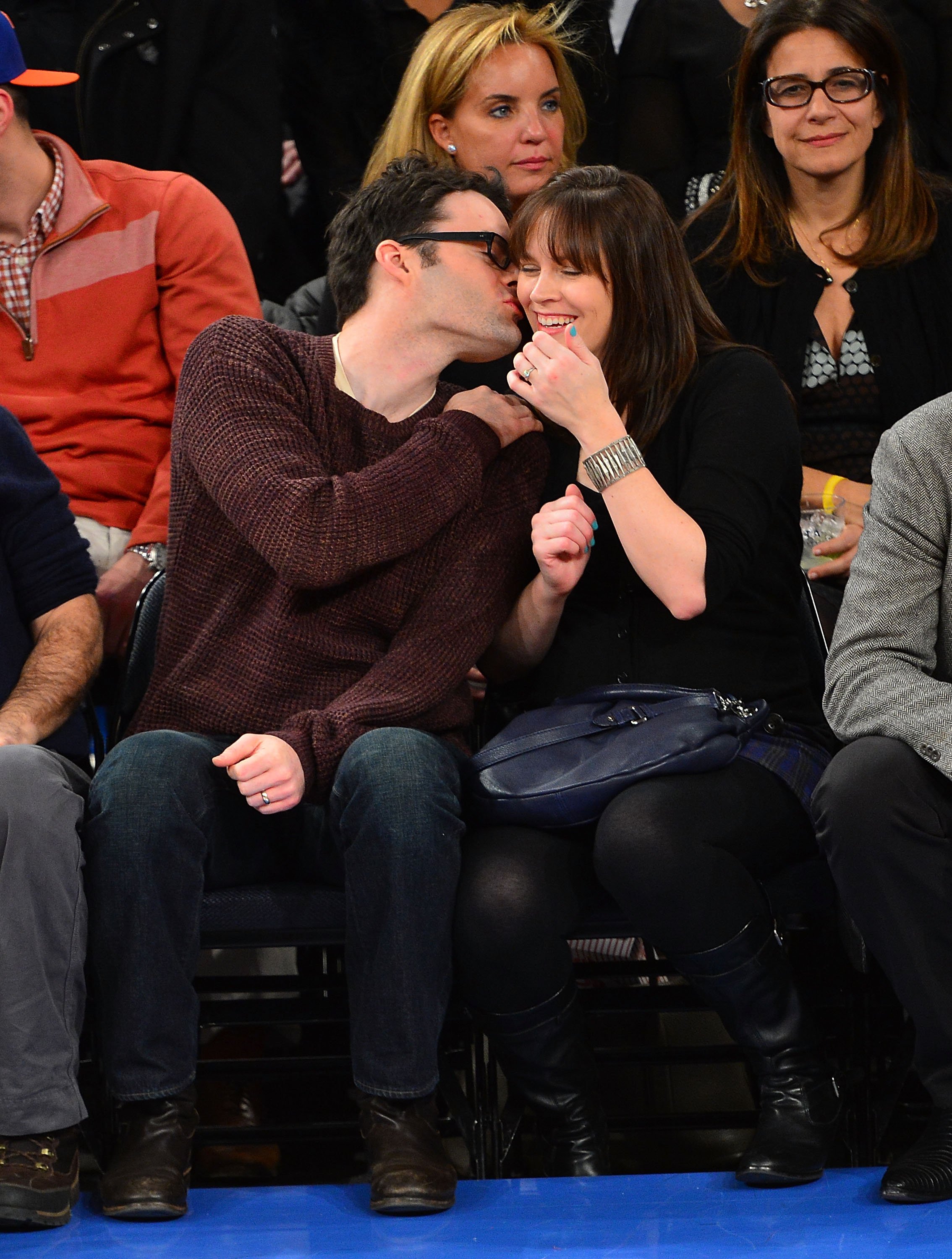 Bill Hader kisses Maggie Carey on her cheek as they attend the basketball game betwene San Antonio Spurs and New York Knicks at Madison Square Garden on January 3, 2013, in New York City. | Source: Getty Images