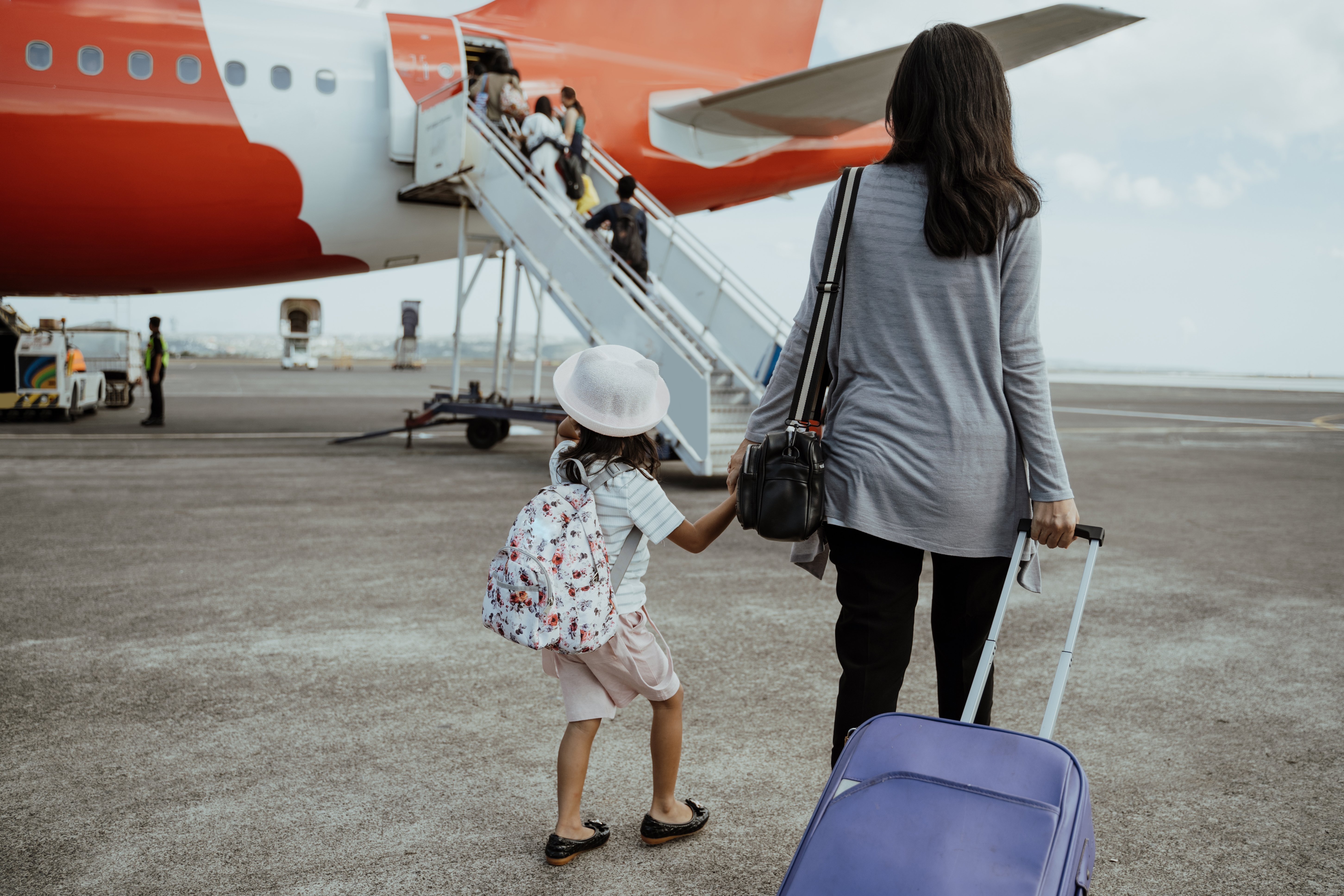 Madre e hija abordando avión. | Foto: Shutterstock