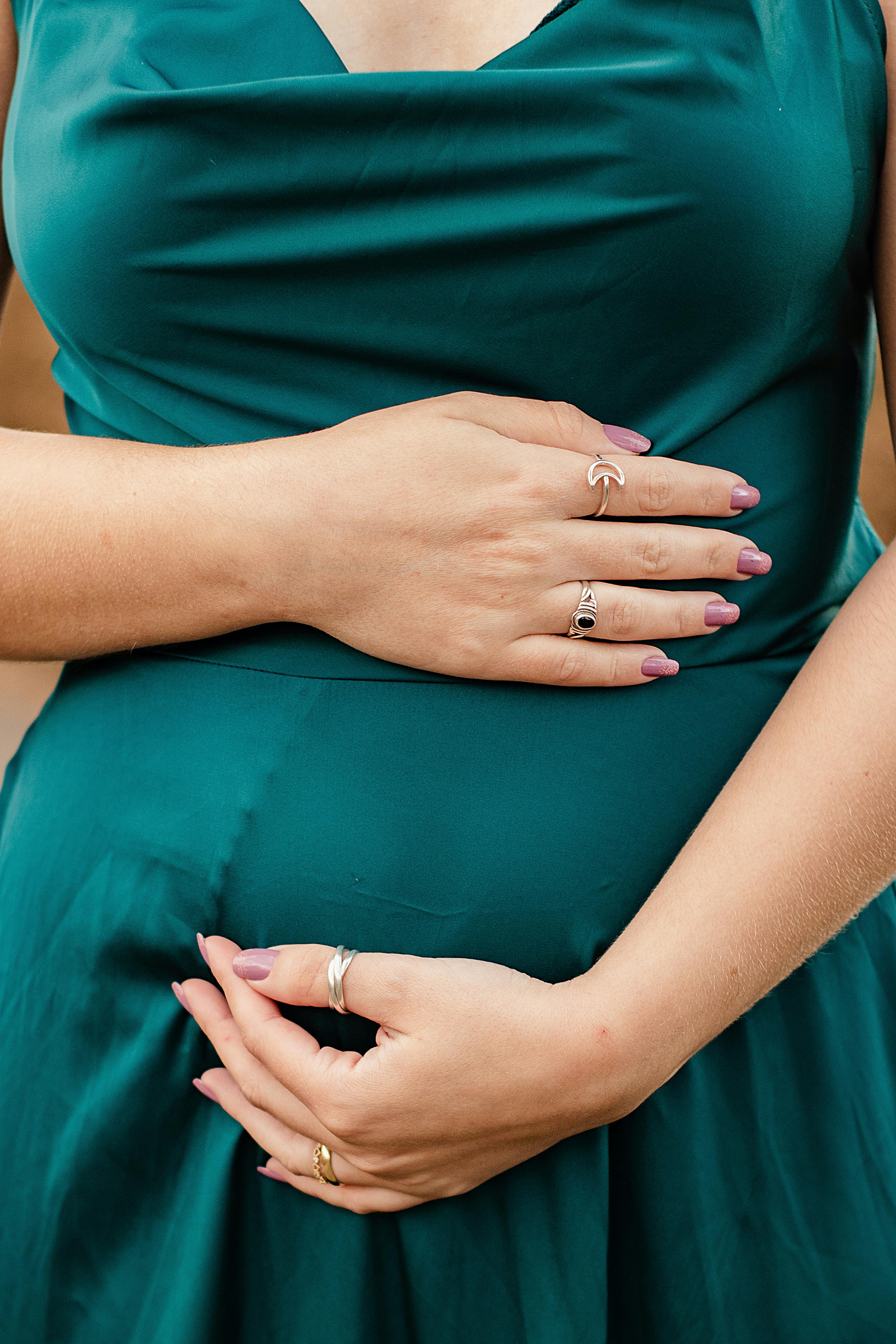 A pregnant woman cradling her baby bump | Source: Pexels