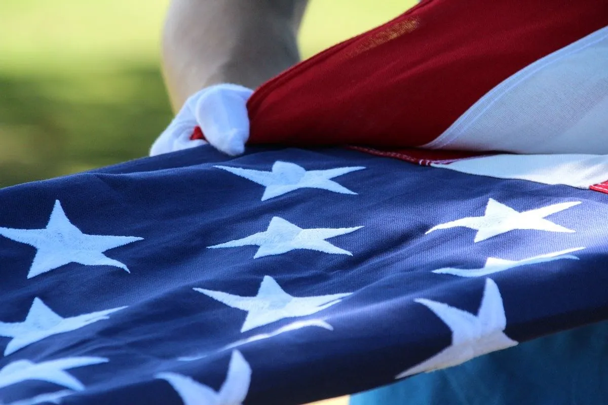 Soldiers with the flag at a veterans memorial | Photo: Pexels