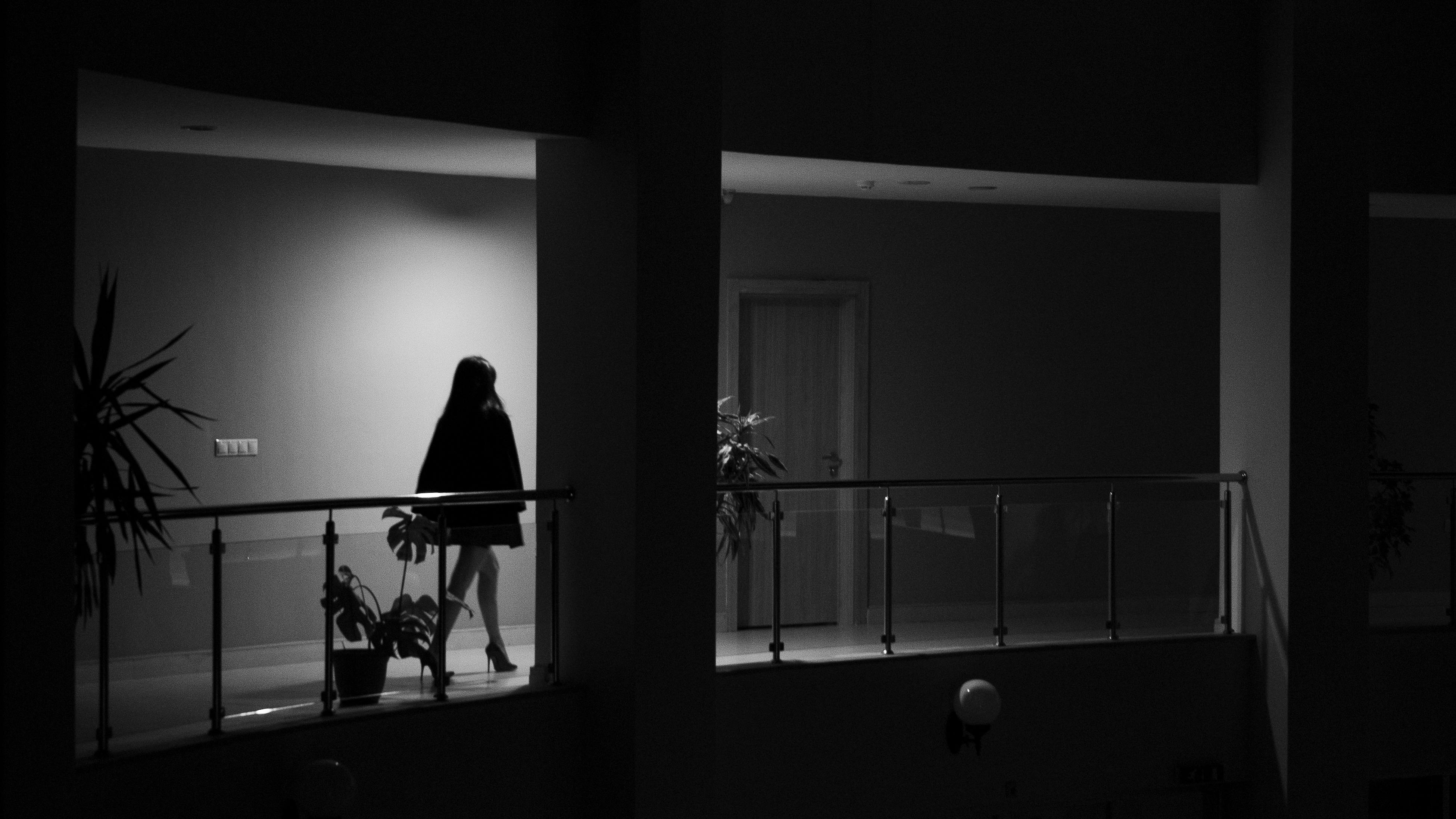 Black and white photo of a woman walking on the balcony | Source: Pexels