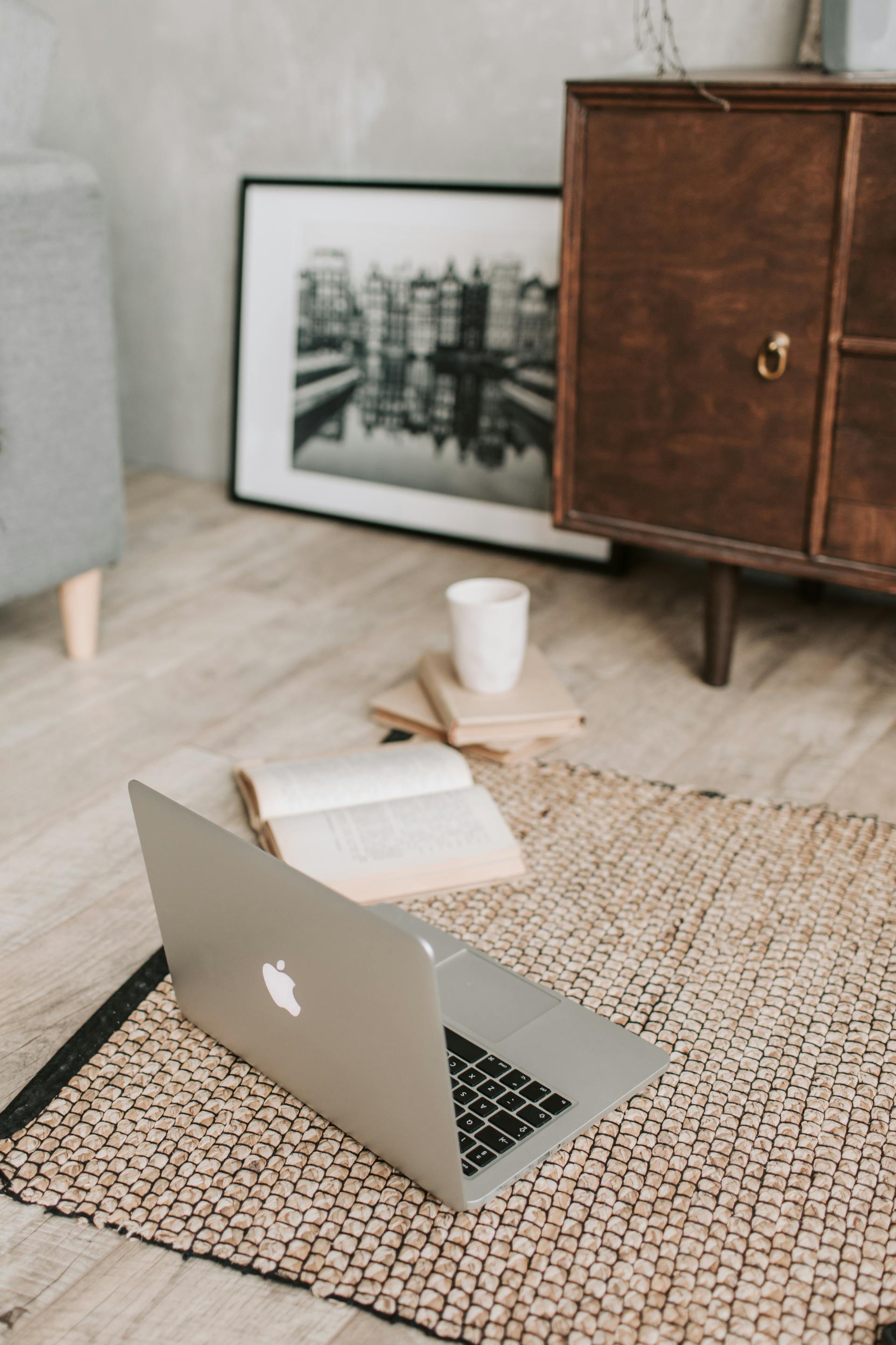 A laptop and books lying on a rug | Source: Pexels