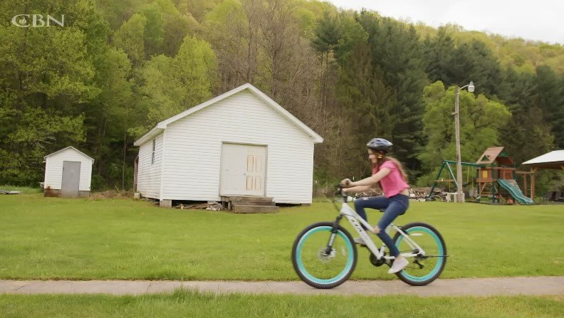 Annie is seen riding a bicyle | Source: Youtube/CBN News
