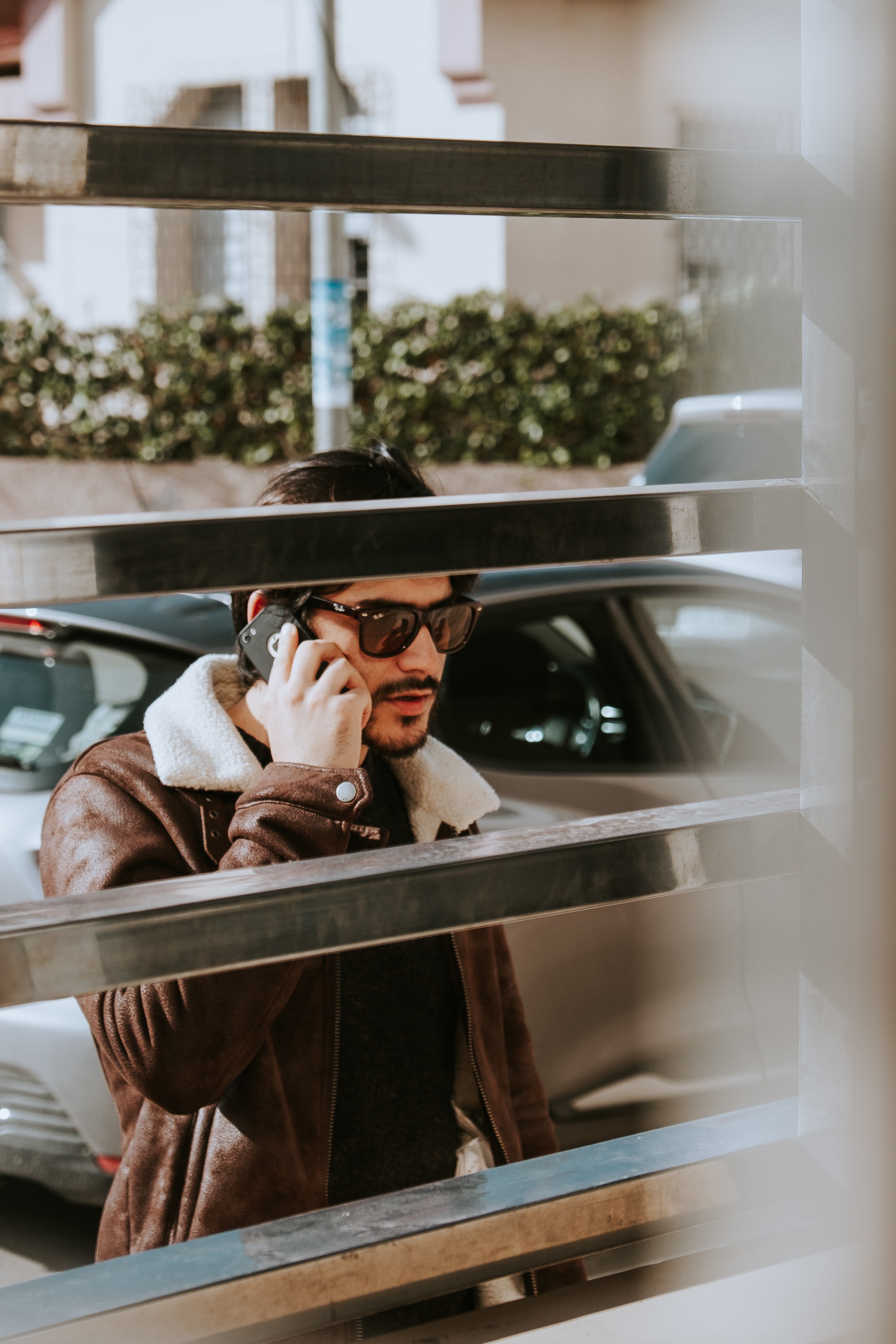 Hombre joven con lentes habla por su celular. | Foto: Pexels