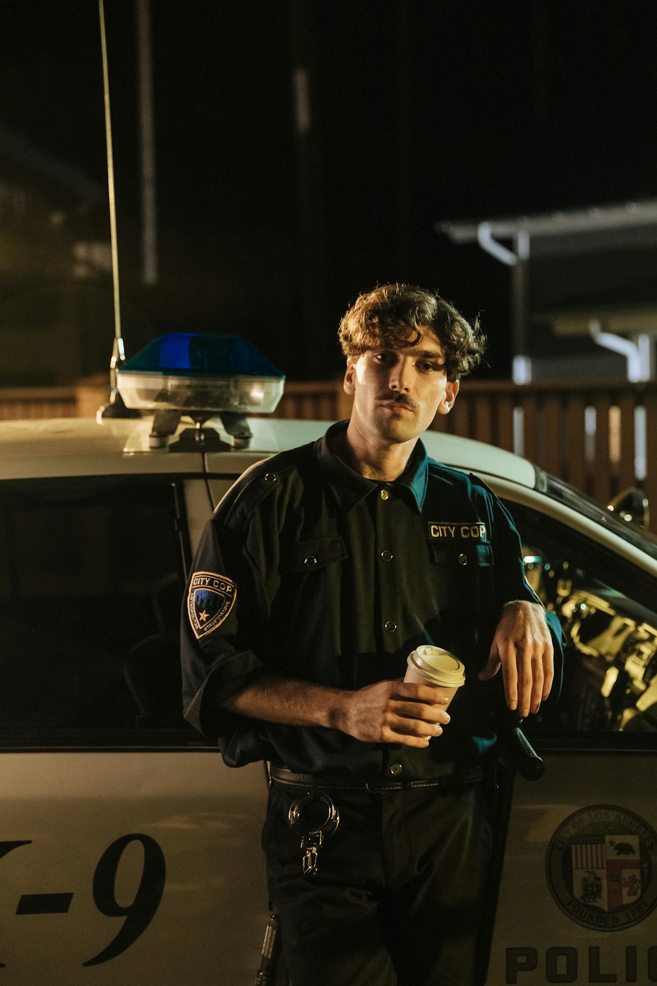 A cop standing outside a police car | Source: Pexels