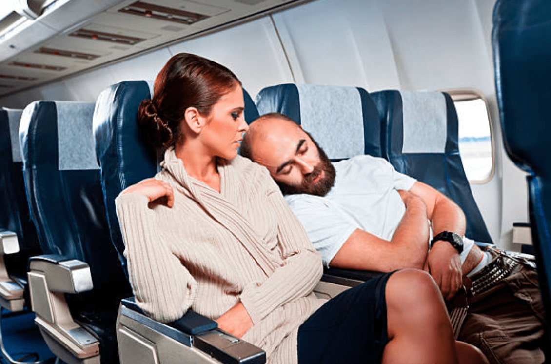 Stranger sleeps on woman's shoulder on a plane | Source: Getty Images