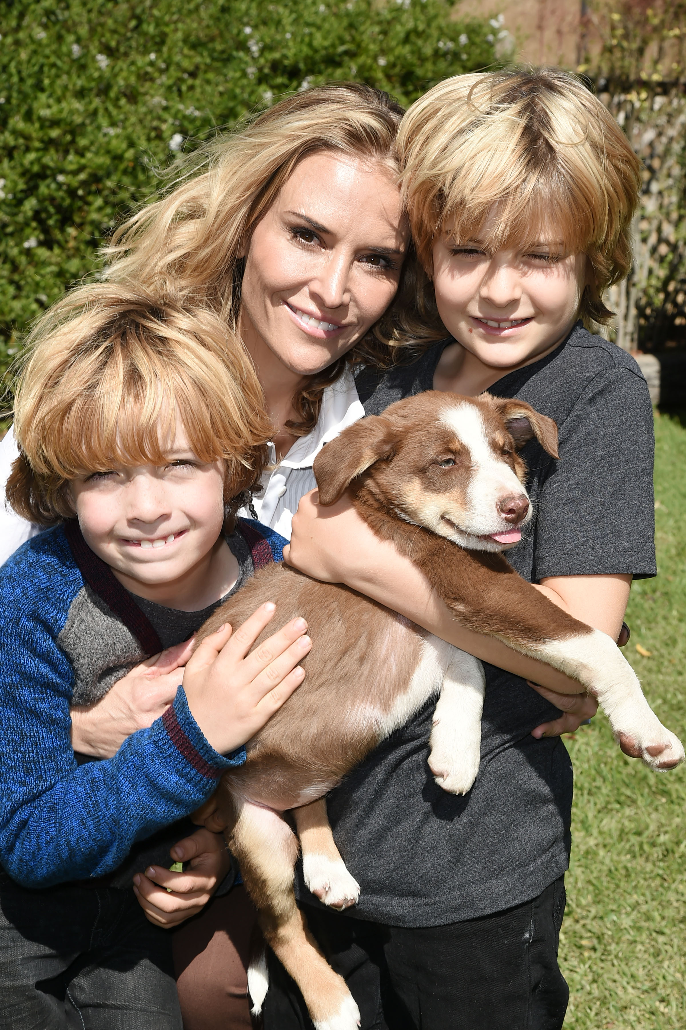 Brooke Mueller with her twin sons Bob and Max Sheen and a puppy during the Hearst Castle Preservation Foundation Annual Benefit Weekend 2016 Luncheon in San Simeon, California on October 1, 2016 | Source: Getty Images