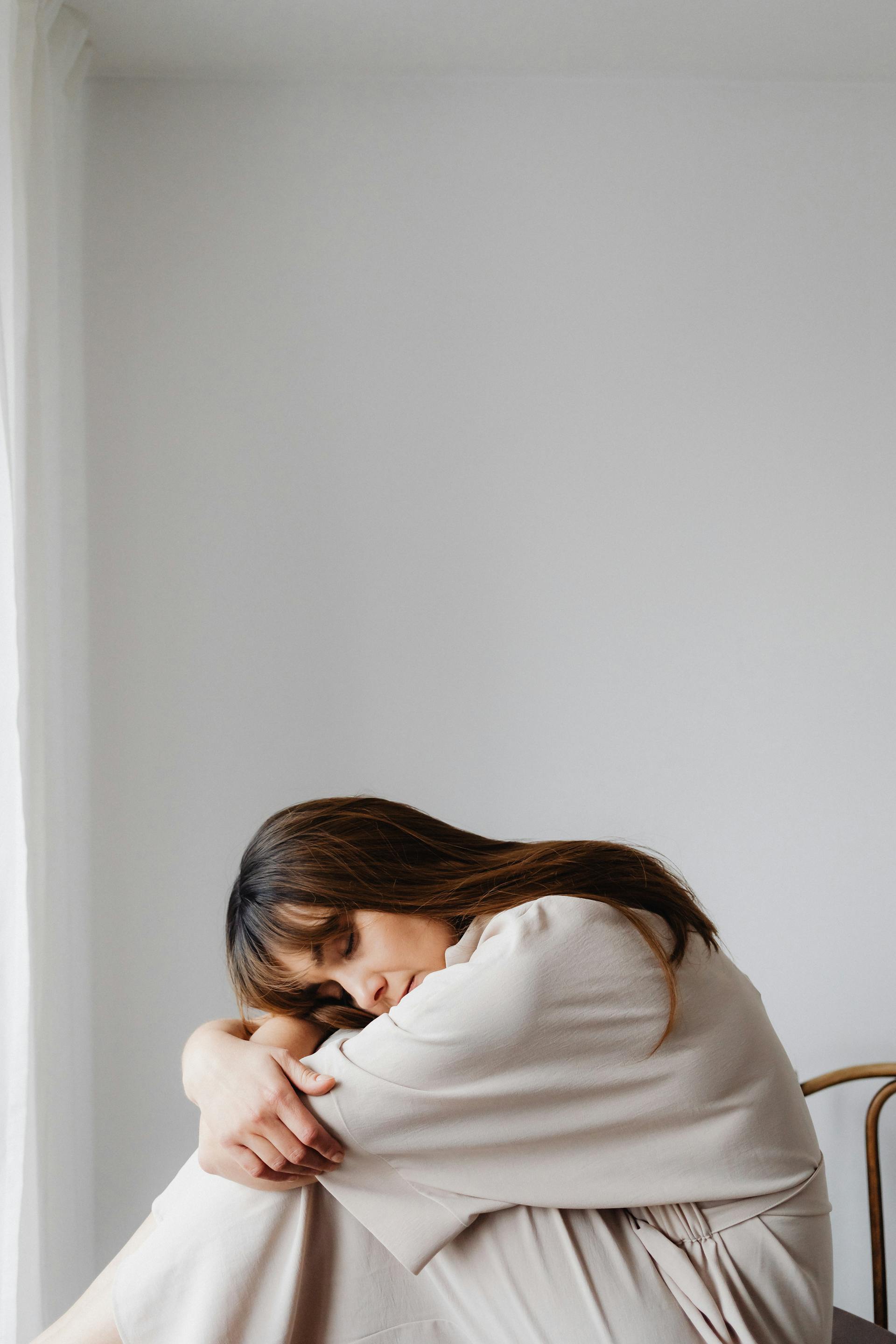A tired woman sitting in a hunched position | Source: Pexels