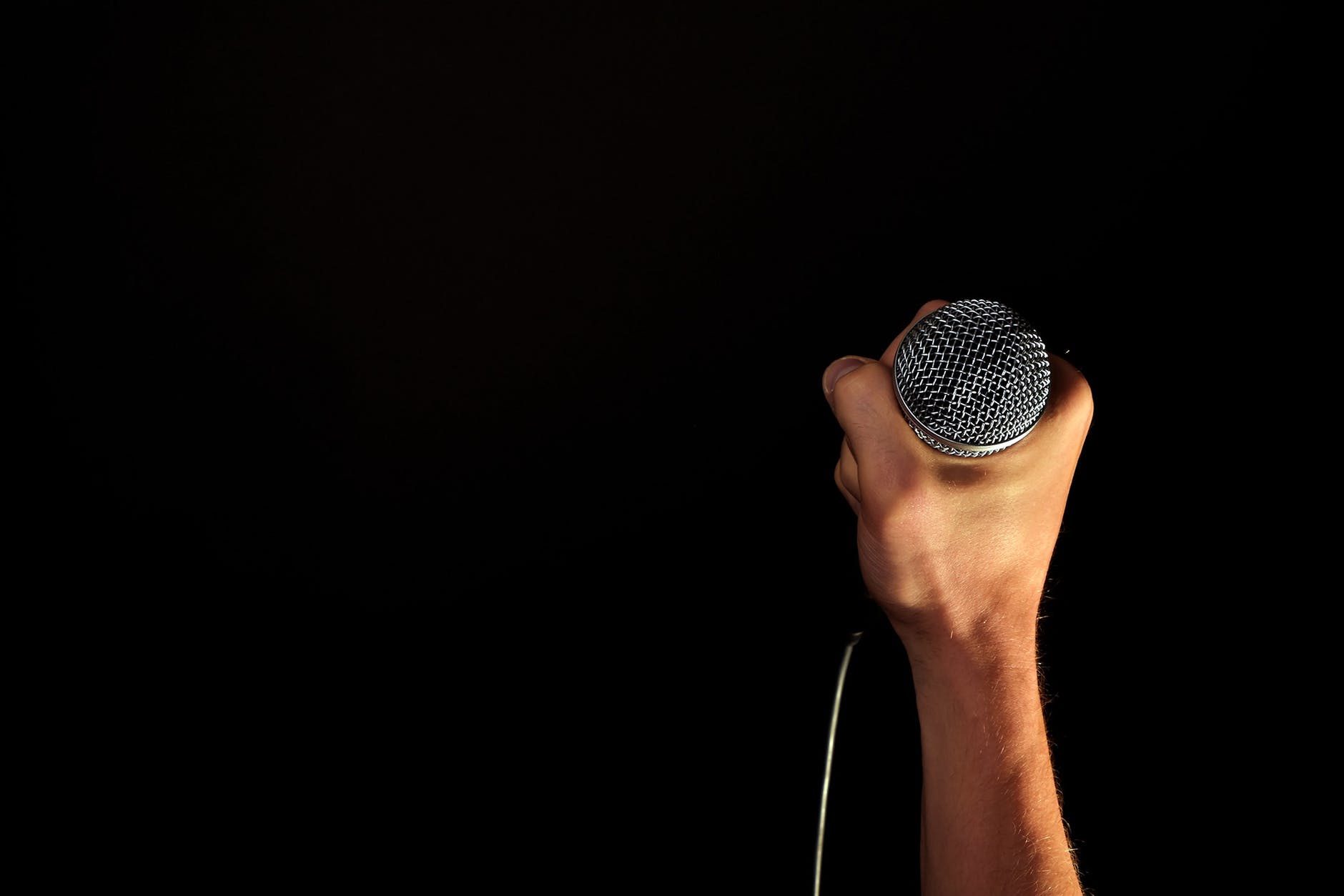 Hand holding a microphone | Source: Pexels