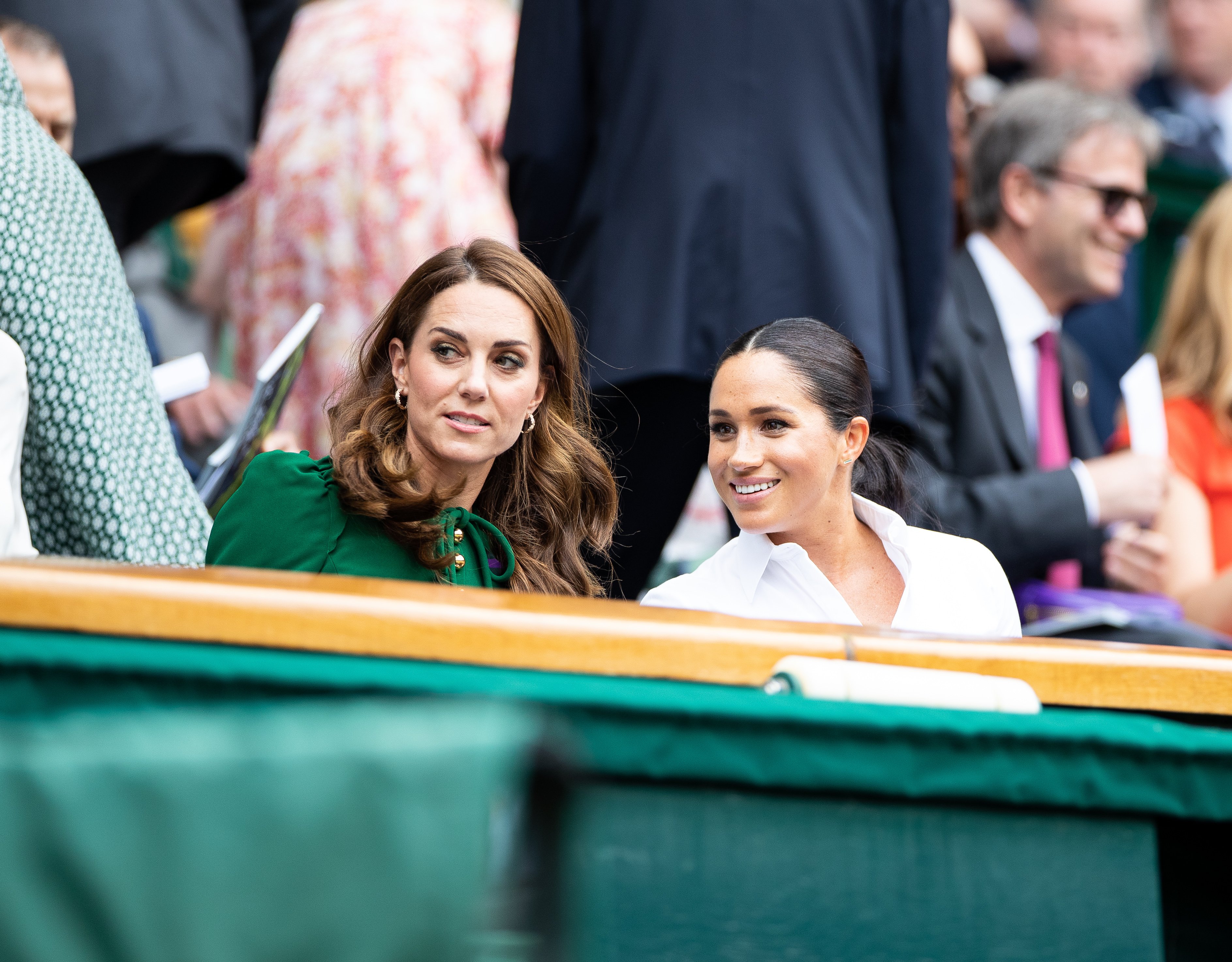 Kate Middleton, Duchess of Cambridge, talks with Meghan Markle, Duchess of Sussex in the royal box before the start of the Women's Singles Final at The Wimbledon Lawn Tennis Championship at the All England Lawn and Tennis Club at Wimbledon on July 13, 2019 in London, England | Photo: Getty Images