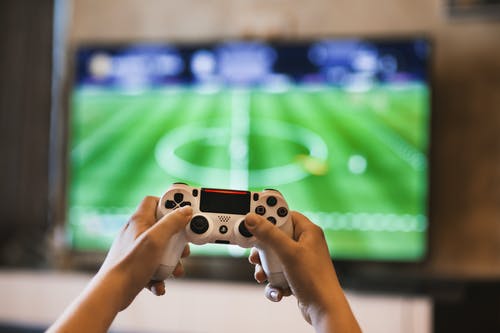 A boy playing with a PlayStation | Source: Pexels