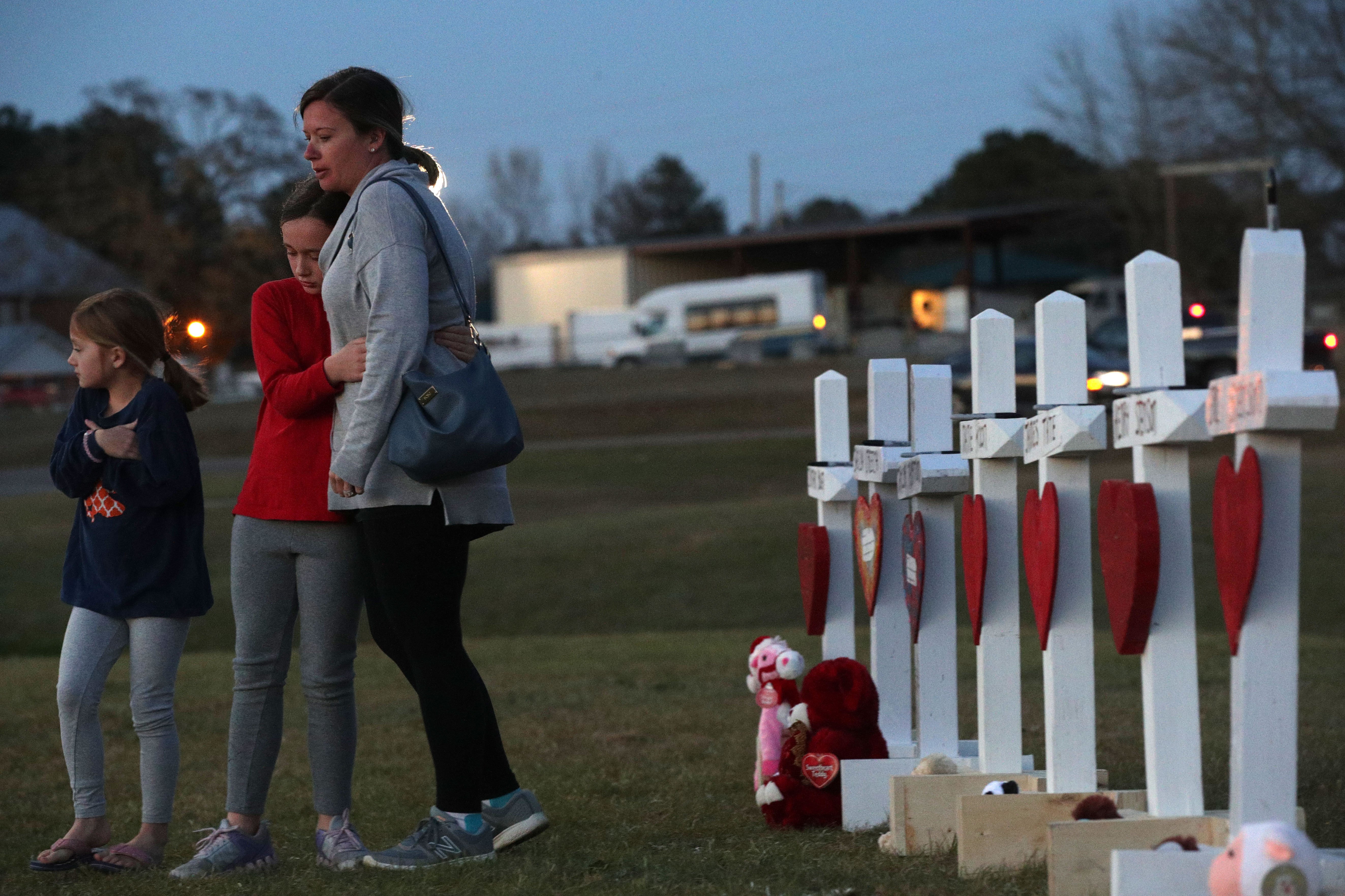 A family paying their respects to a friend who passed during the Tornado in Opelika, Alabama | Photo: Getty Images