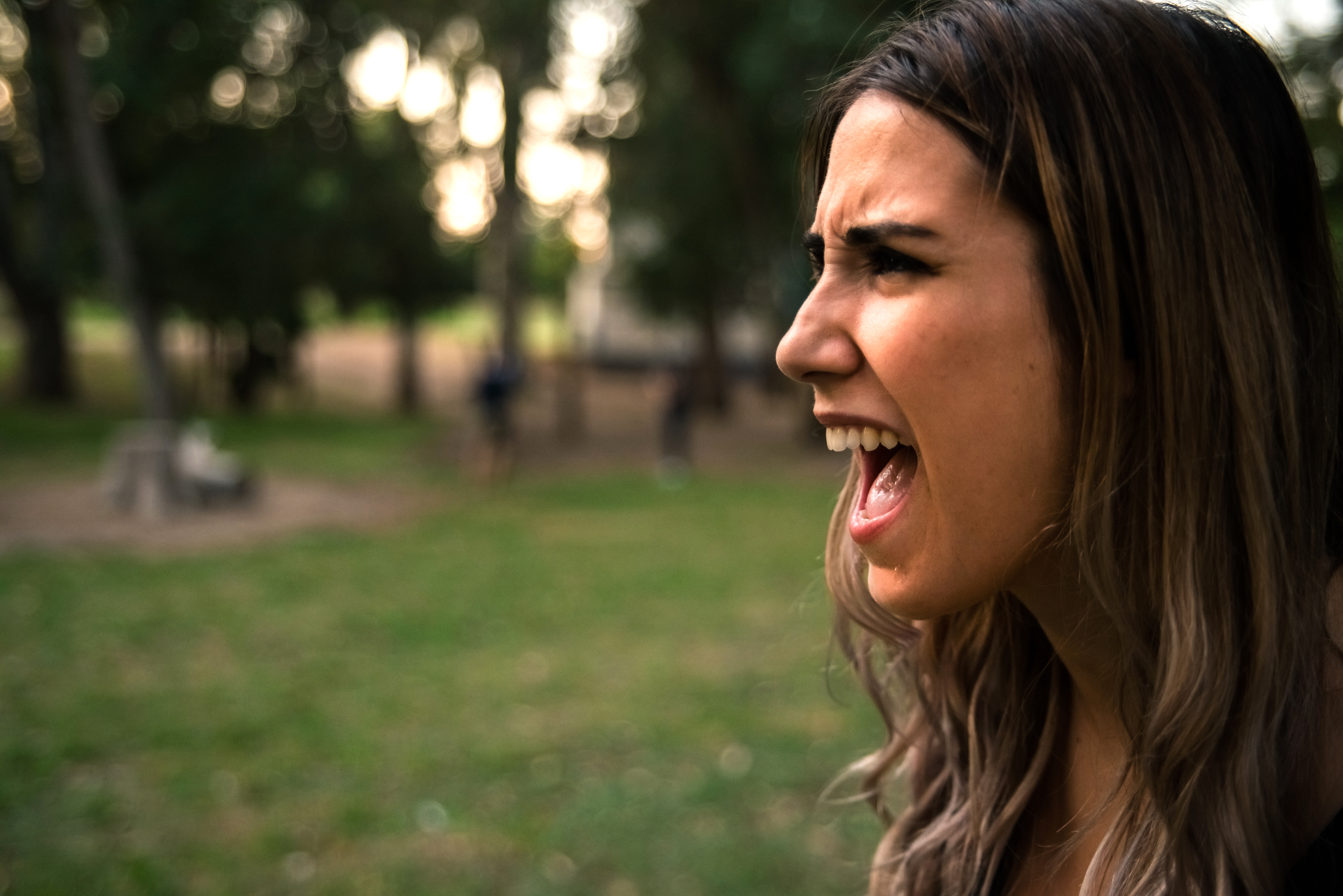 Eine Frau, die mit offenem Mund abgebildet ist, während sie im Freien schreit | Quelle: Shutterstock