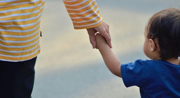 Mujer sostiene a niño de la mano. | Foto: Pixabay