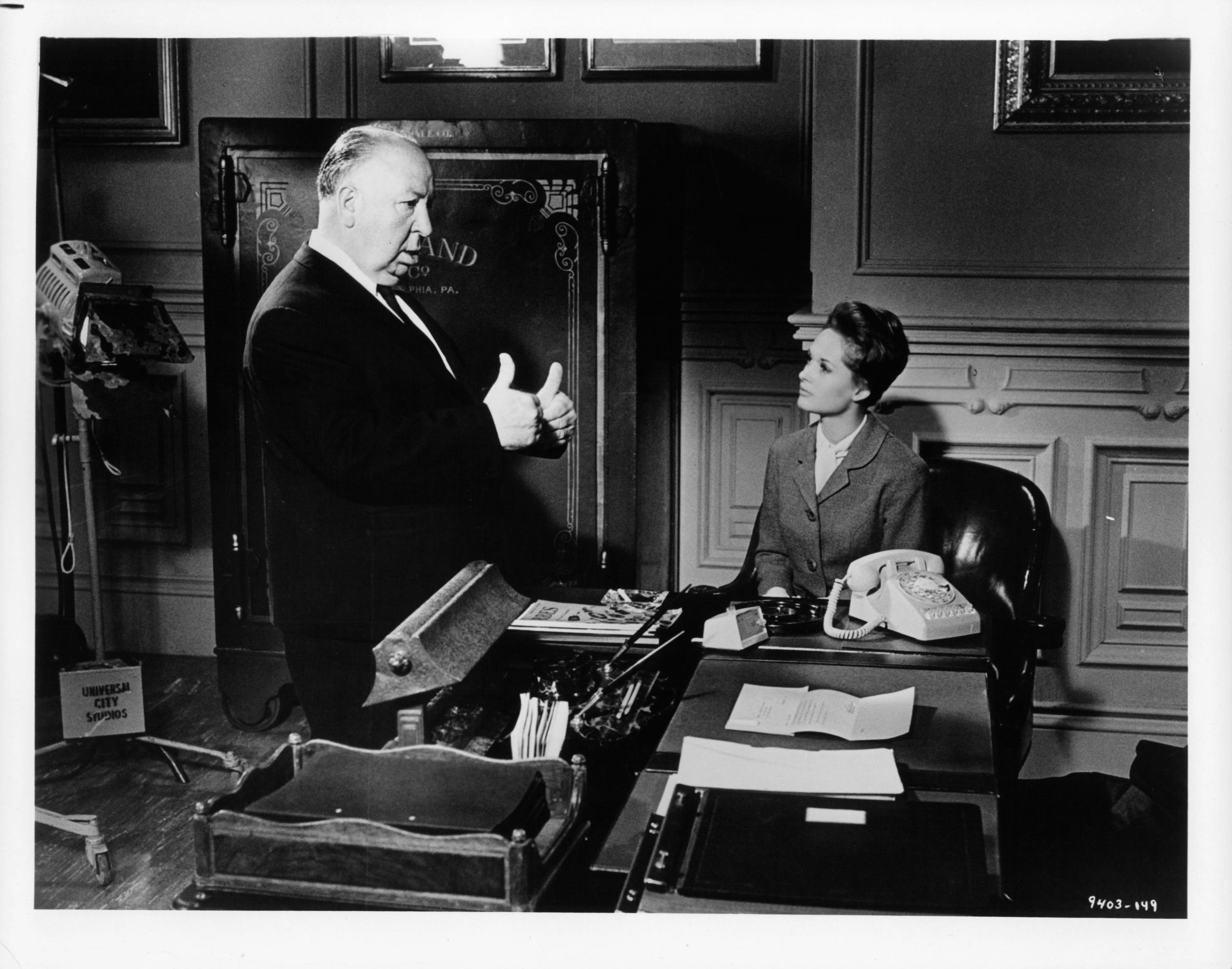 Alfred Hitchcock gives Tippi Hedren directions in between scenes from the film "Marnie" in 1964. | Source: Getty Images