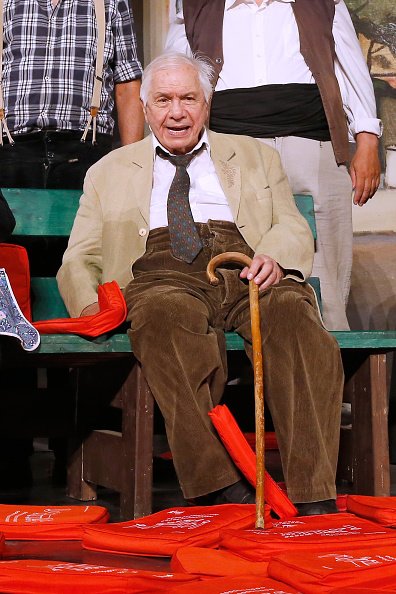 Michel Galabru reconnaît les applaudissements du public whyle le traditionnel lancer de coussins lors de la finale de la pièce de théâtre `` Jofroi '' pendant le 31e Festival de Ramatuelle: Jour 11, le 11 août 2015 à Ramatuelle, France . | Photo : Getty Images