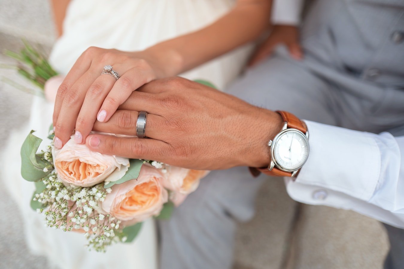 Braut und Bräutigam halten sich an den Händen | Quelle: Unsplash