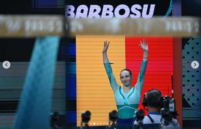 Ana Barbosu beams with a raised hand during the Artistic Gymnastics Women's Floor Exercise at the 2024 Paris Olympics, posted in August 2024 | Source: Instagram.com/ana_barbosu